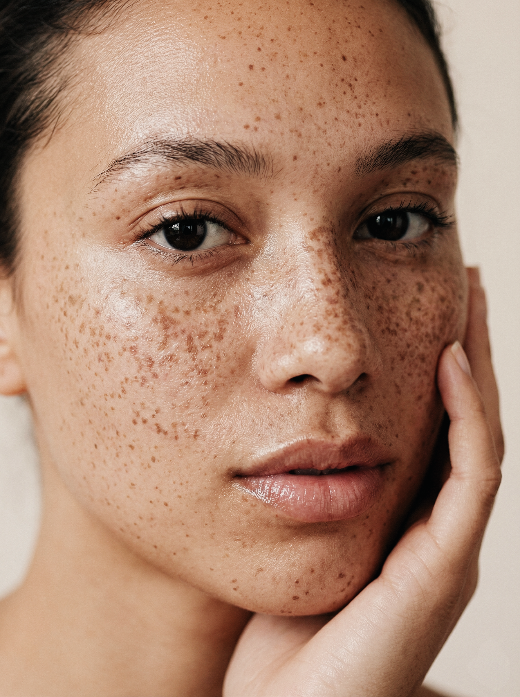 Detailní beauty portrét s přirozenou texturou pleti a pihami, čistý editorial styl, jemné denní světlo, přirozený make-up, estetika prémiové skincare kampaně