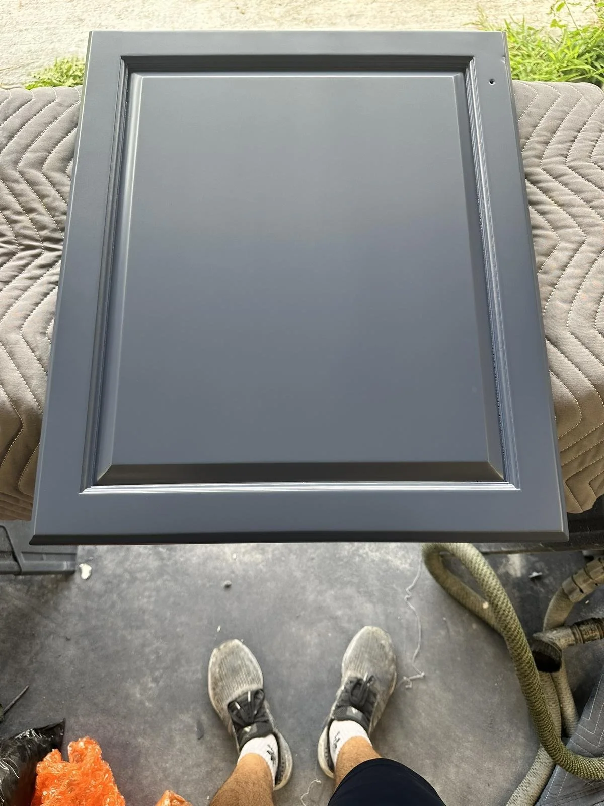 Oak cabinet door refinished in bold navy blue, chip-resistant smooth finish.