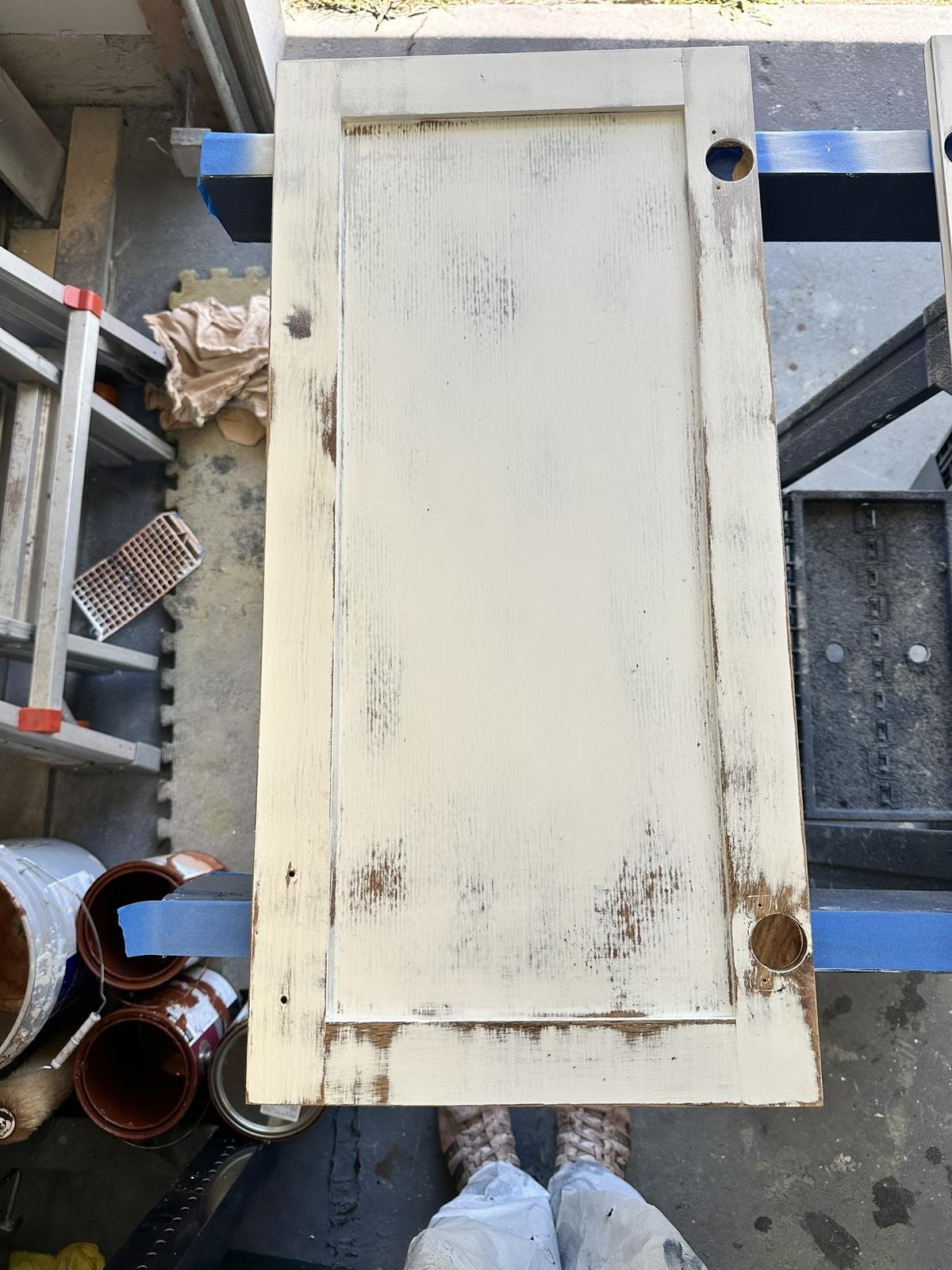 Close-up of oak cabinet door sanded smooth after primer, preparing for final paint finish.
