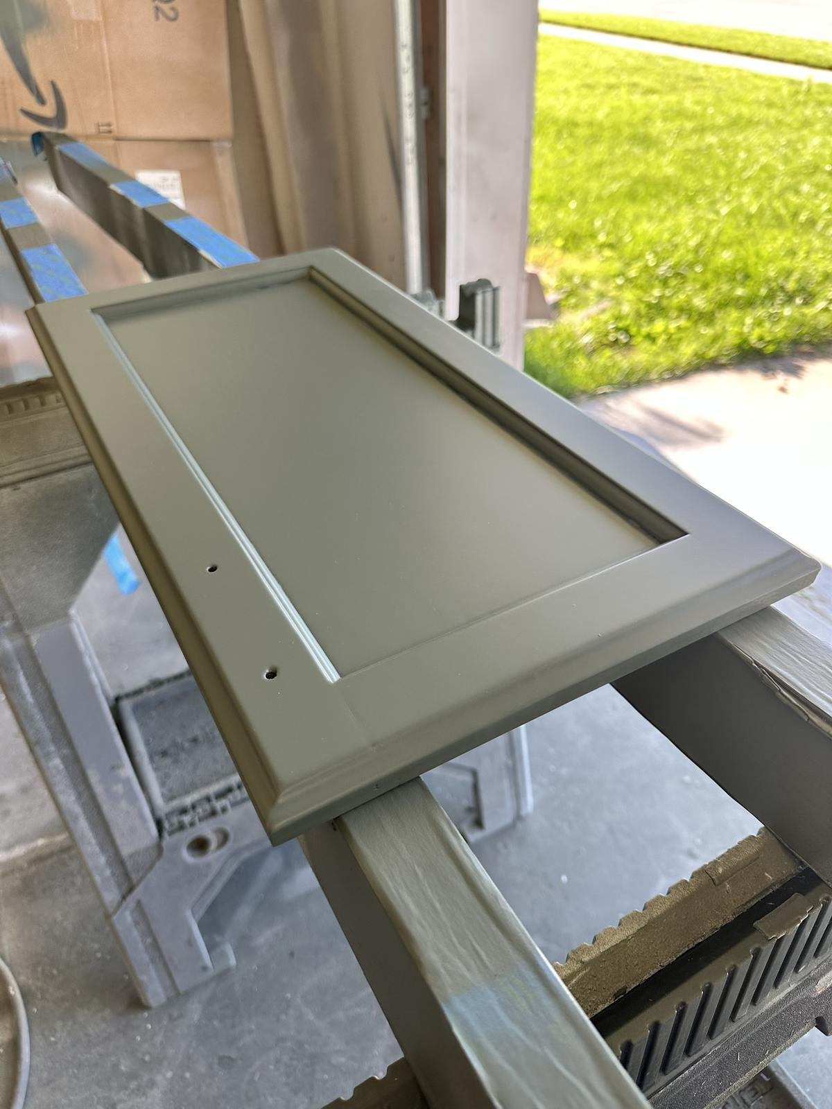 Refinished oak cabinet door painted gray, smooth and durable finish after sealer and primer.