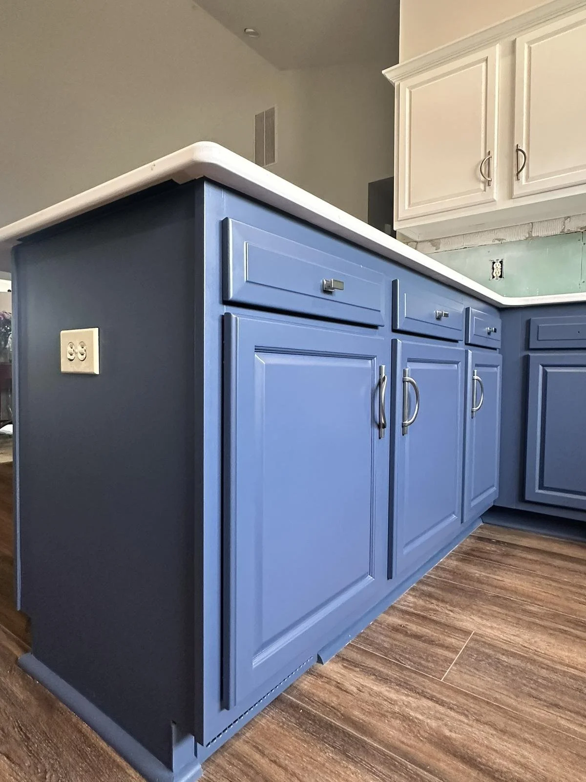 Kitchen with two-tone cabinets refinished in blue lowers and white uppers for modern style.
