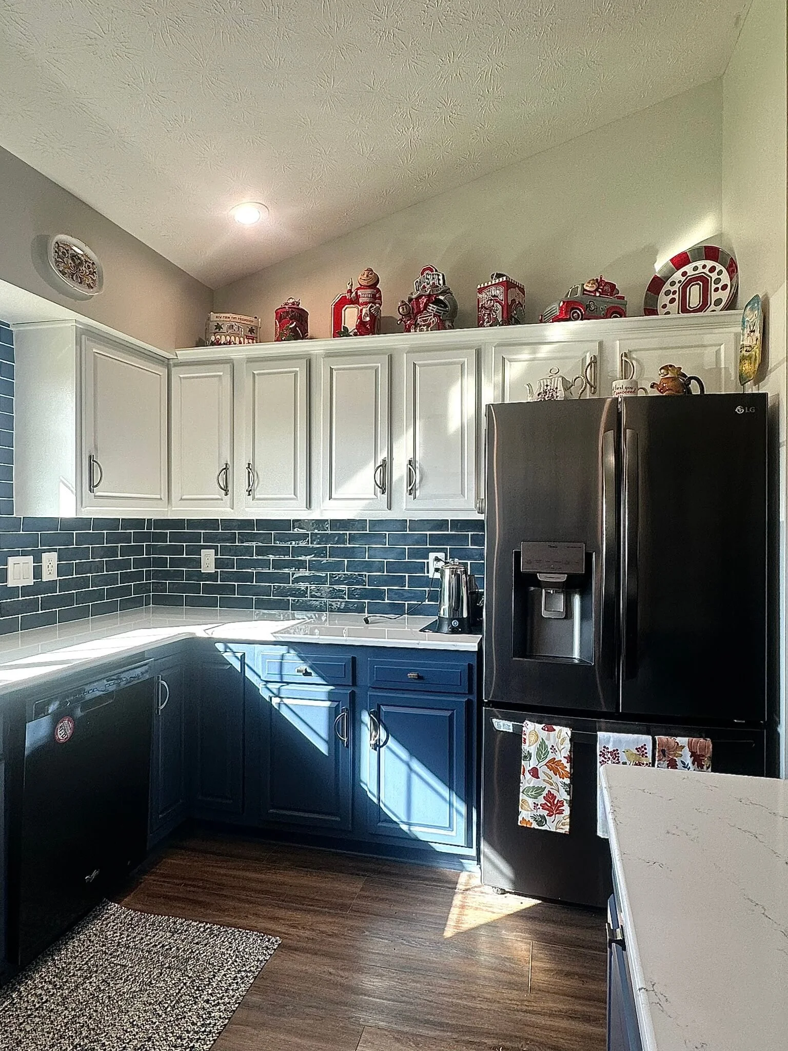 Two‑tone blue lower and white upper refinished kitchen cabinets with a smooth sprayed finish in a Dayton, Ohio home.