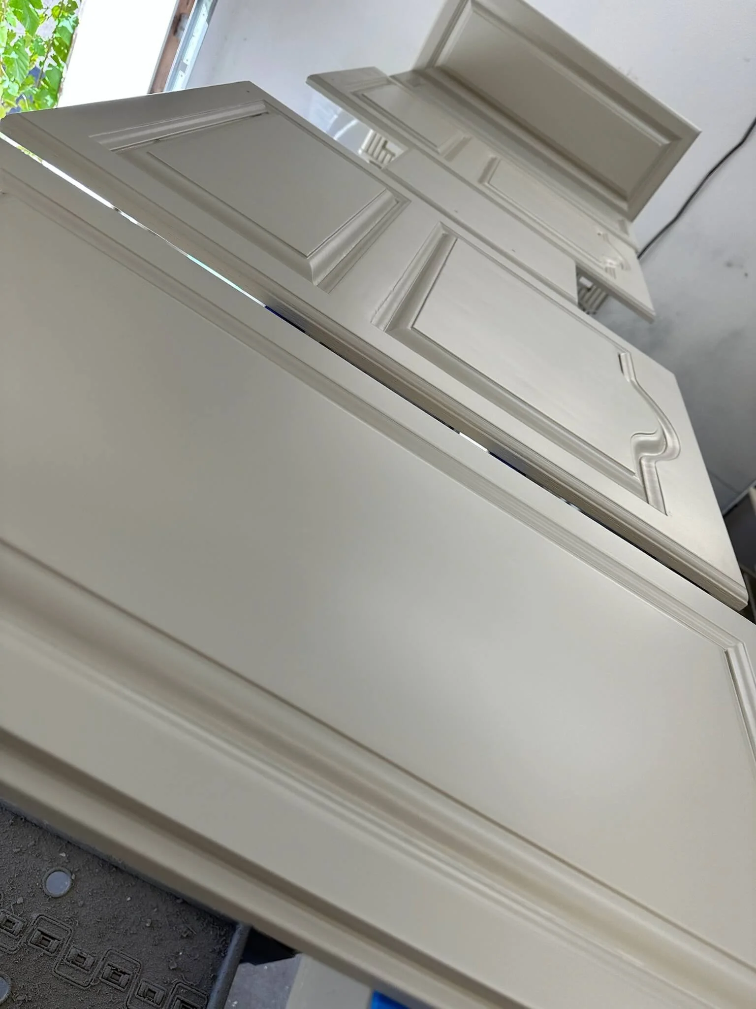 Off-white spray-finished cabinet doors curing on racks