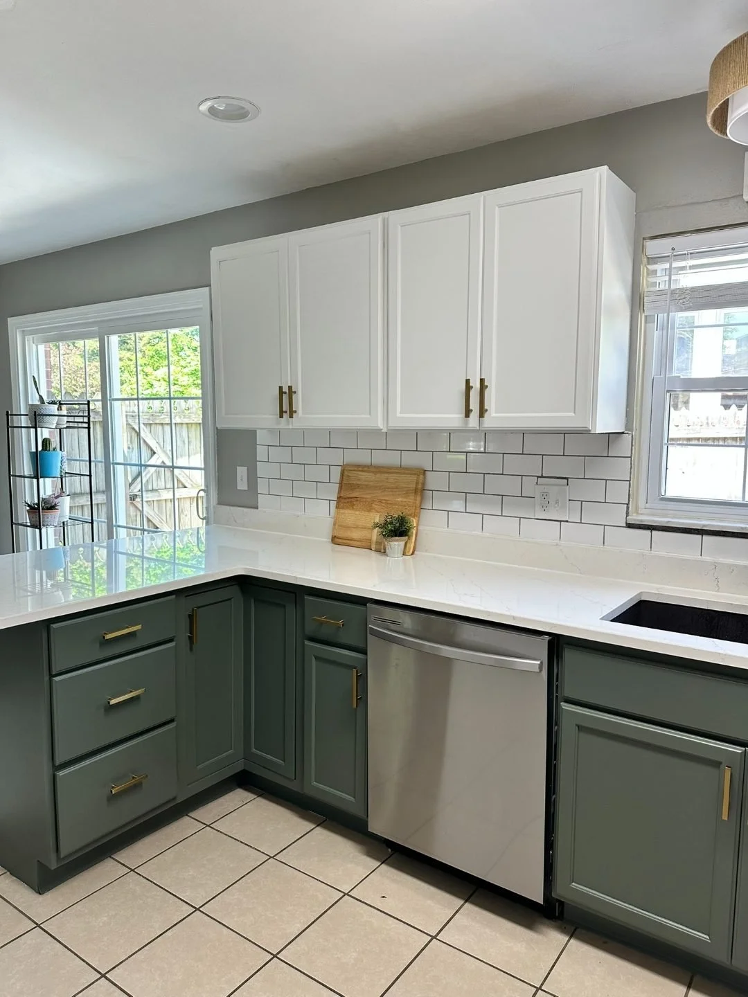 White upper cabinets with green base cabinets and stainless dishwasher