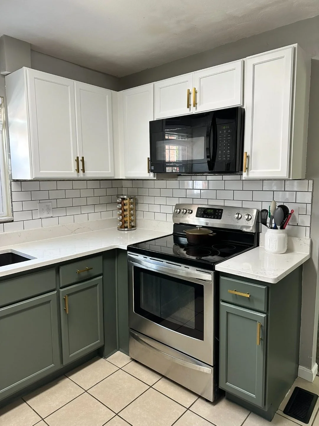  Wide view of two-tone kitchen: white uppers, green lowers, brass hardware