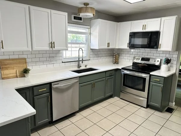 A two-tone cabinet update featuring crisp white upper cabinets and deep green lower cabinets for a clean, modern contrast. This color split keeps the kitchen bright up top while adding depth and warmth at base level, creating a fresh, designer-inspir
