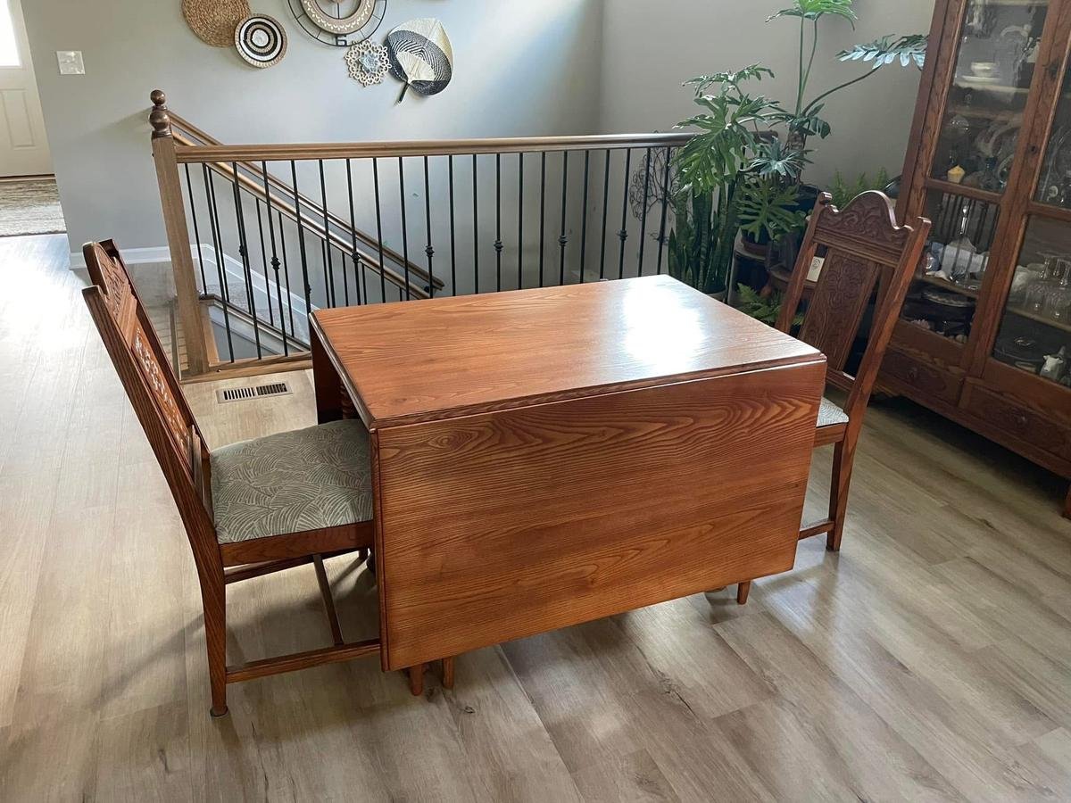 A vintage drop-leaf wooden table with two ornate chairs from Craft & Revive in Oakwood, OH, set in a bright, stylish home space.