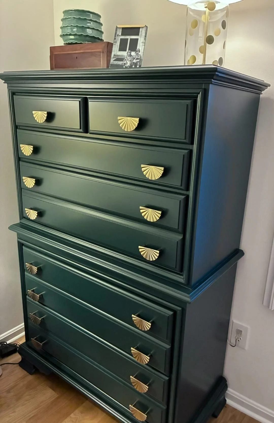Dark green painted highboy dresser with bold brass shell pulls, featuring a classic stacked-drawer layout and deep, modern color that makes the vintage piece feel updated and upscale