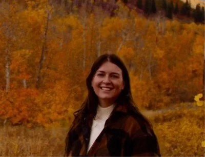 Smiling woman with long brown hair in nature