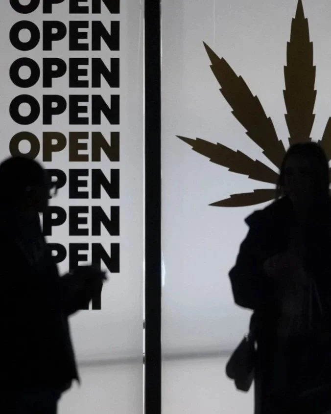 People stand in front of "Now Open" signage and a marijuana plant image in Mississauga, Feb. 26, 2025. Photo by Peter J. Thompson /National Post