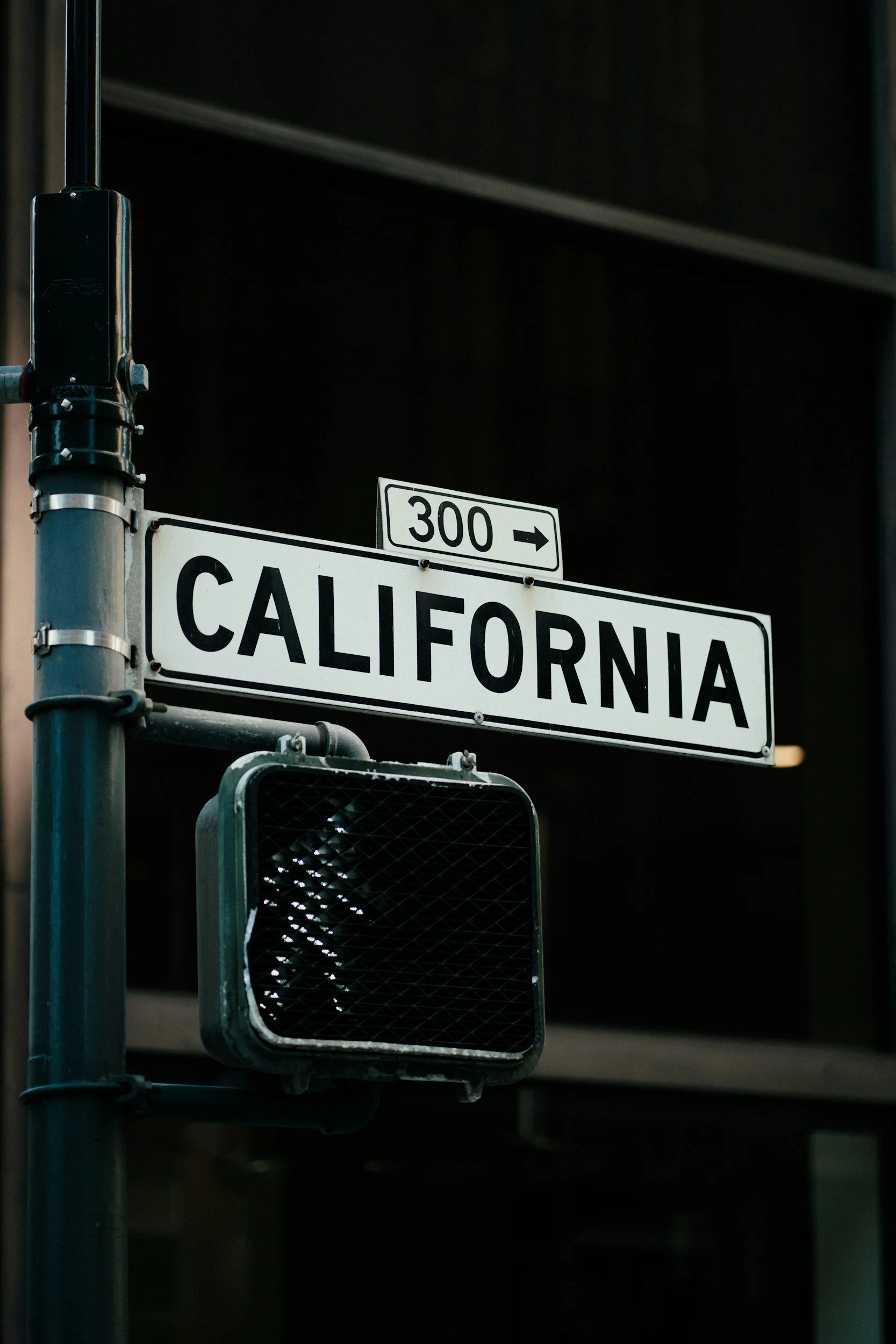 A street sign that says 'California' with an arrow and a small sign indicating route 300, along with a traffic signal at an intersection.