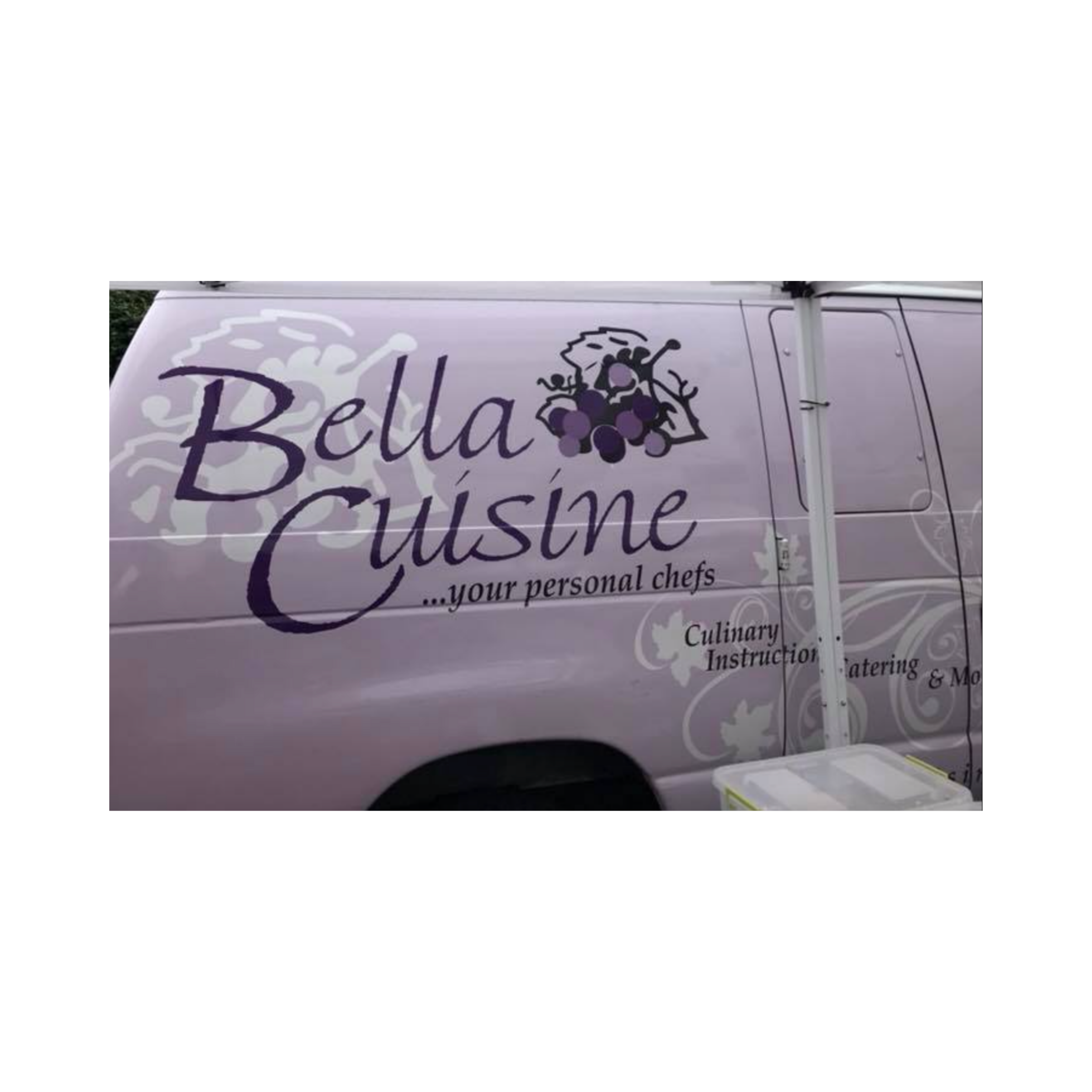 Photo of a white van with purple text and grapevine graphics that reads "Bella Cuisine," indicating it is related to food or catering, parked outdoors.