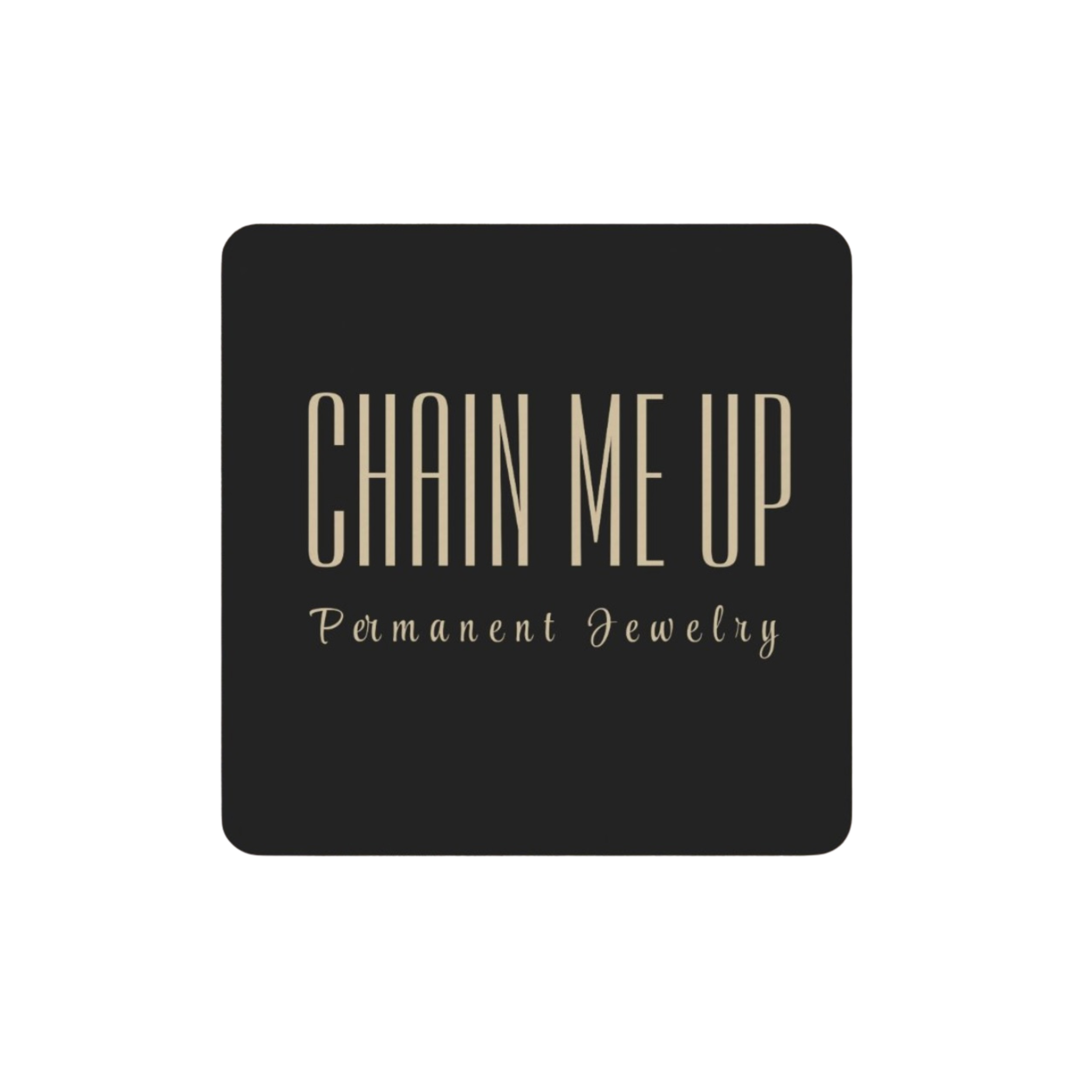 Black jewelry display card with beige text reading "QUON ME UP" and smaller beige text "Permanence Jewelry" beneath, set against a black background.