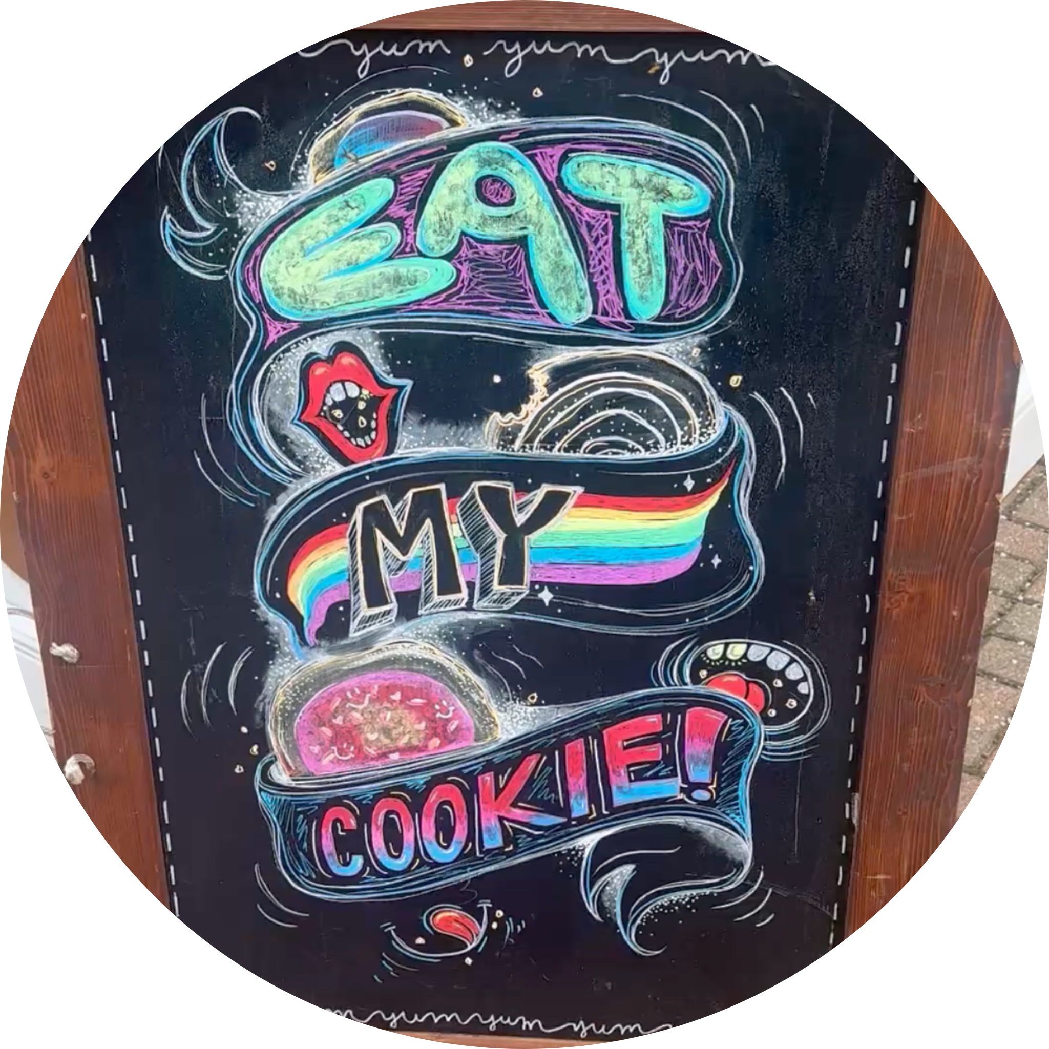 Colorful chalk art on a chalkboard featuring the phrase "LOVE LIKE COOKIES" with various decorative elements including a rainbow, lips, and swirling designs.