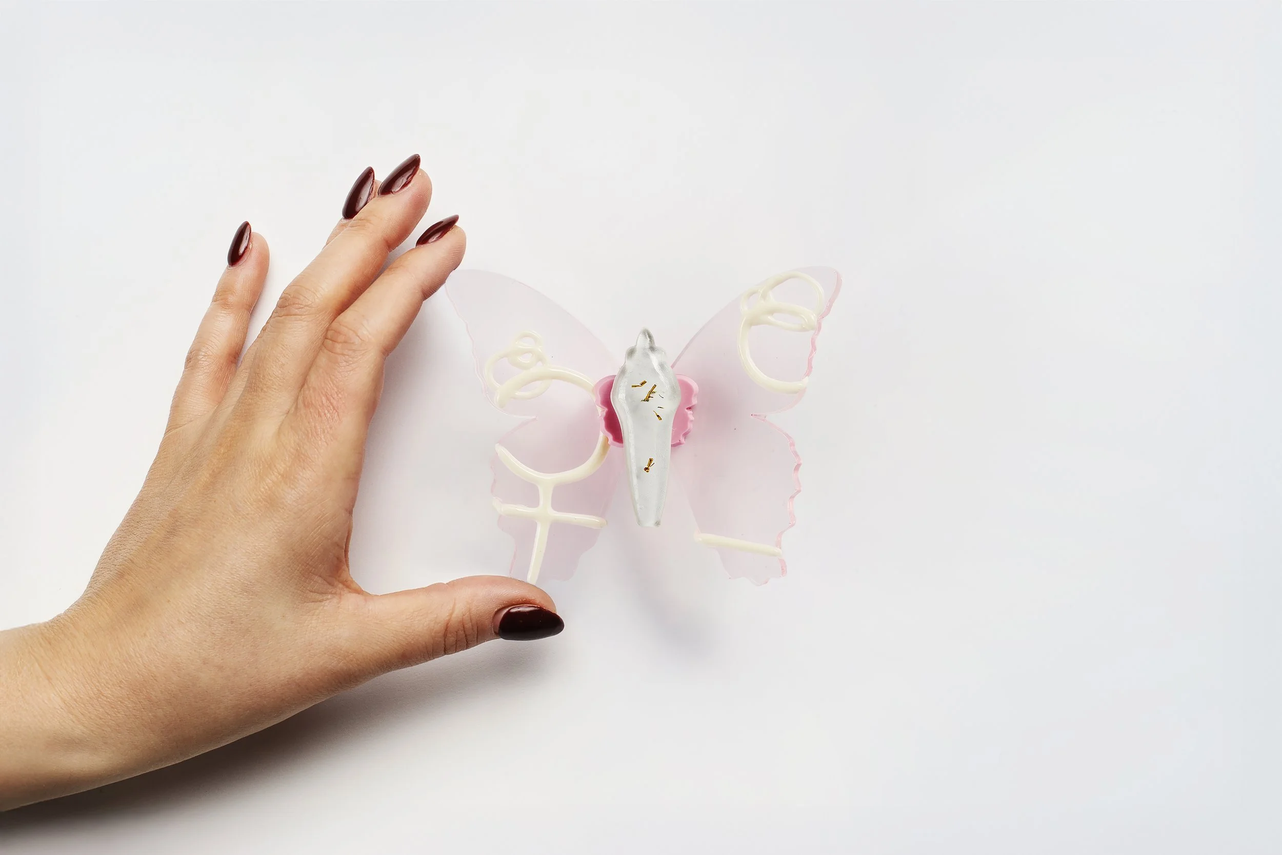 Miniature pink soft resin butterfly art featuring female symbols representing the community affected by the Killeen, TX mass shooting