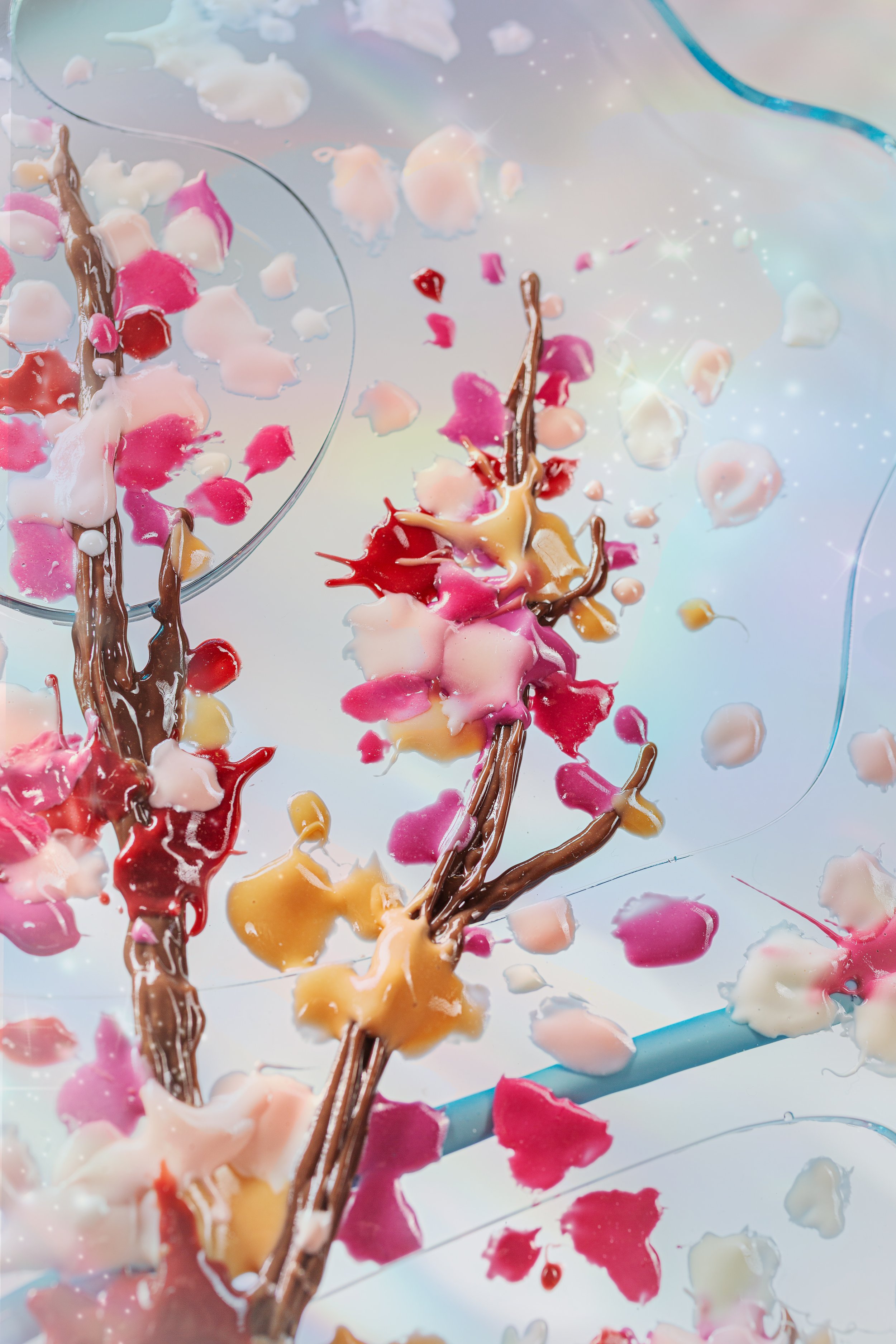 Colorful paint splatters on a resin butterfly wing with abstract cherry blossoms.