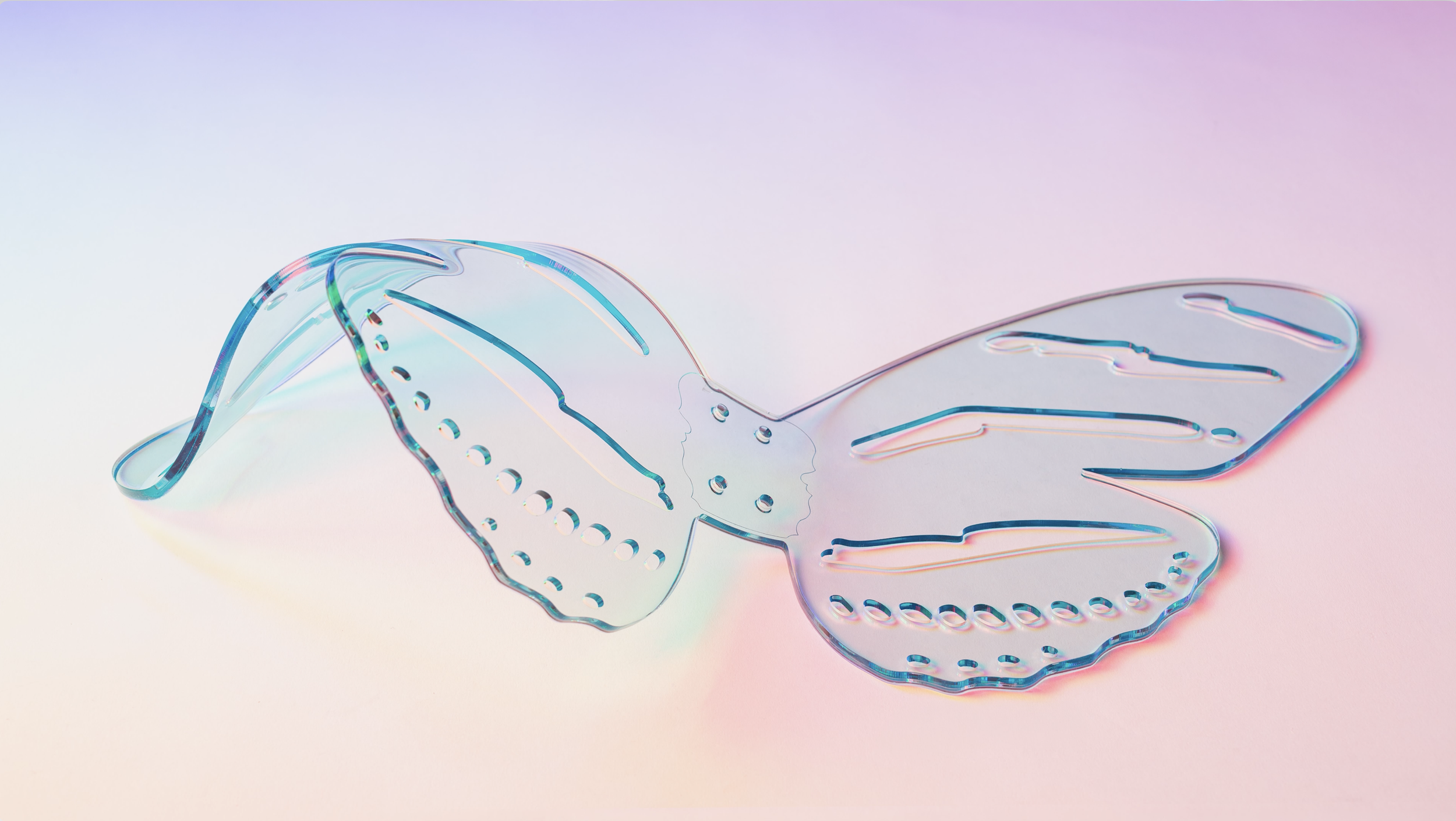 Iridescent resin butterfly wings on a pastel background.