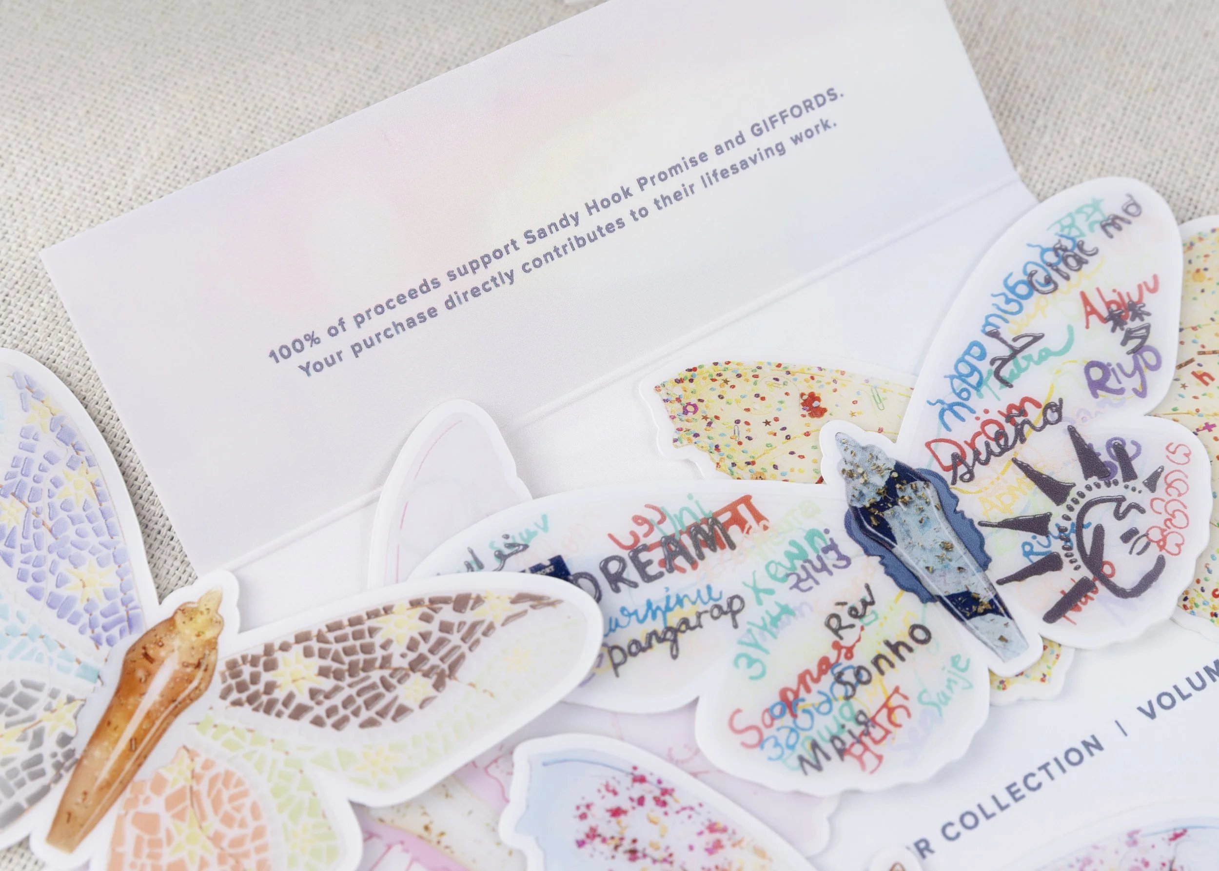 Detail of the Resilience butterfly sticker collection packaging highlighting that 100% of proceeds support GIFFORDS and Sandy Hook Promise.