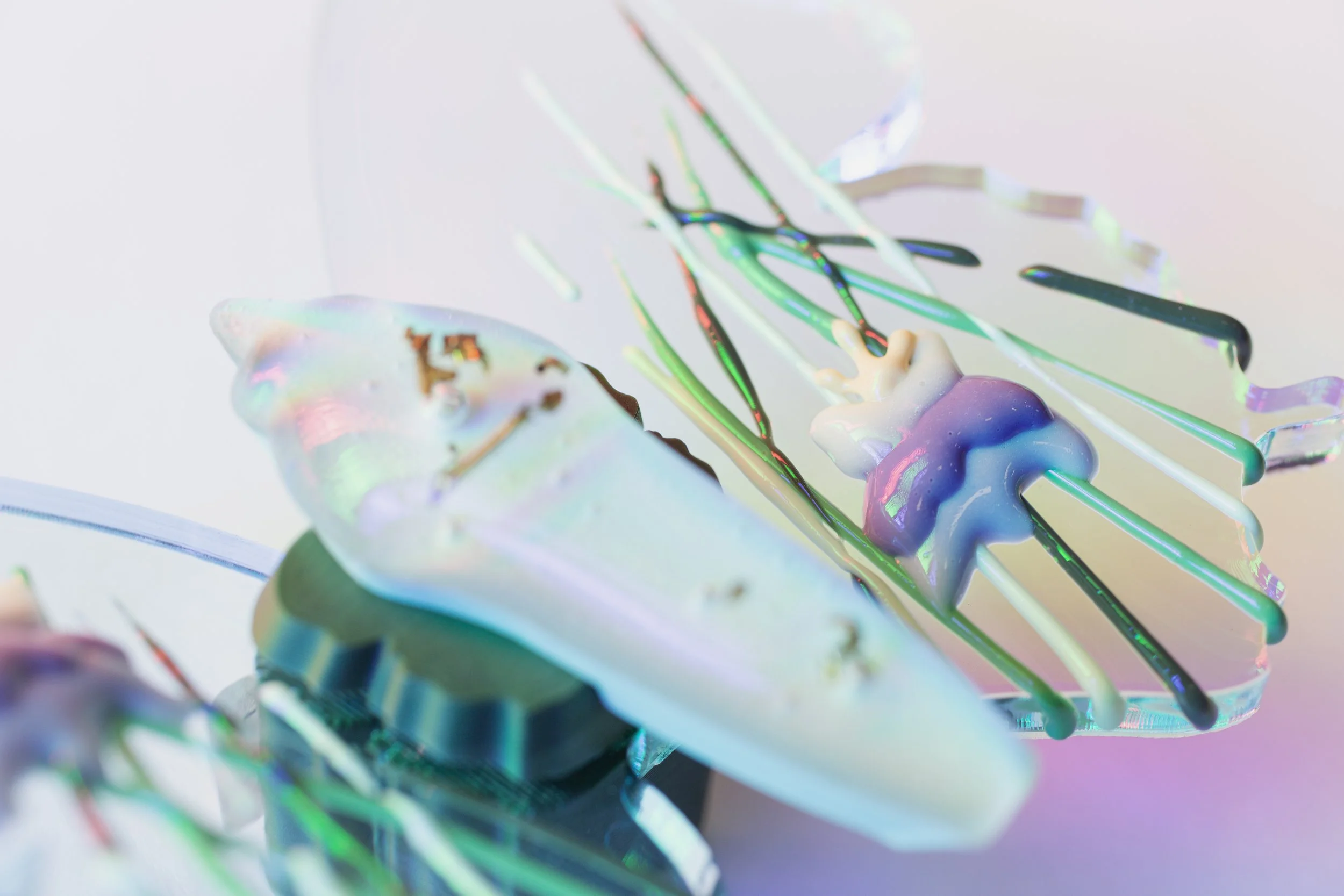 Close-up of iridescent resin on a surface, with rainbow-like colors and streaks.