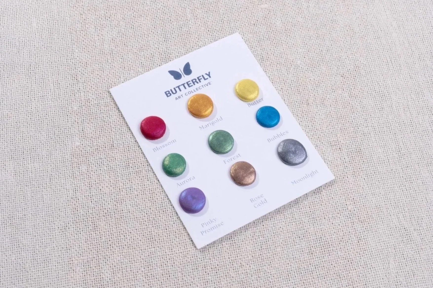 Close-up of the Resilience watercolor palette card featuring nine colorful metallic paint samples arranged on a white card with the Butterfly Art Collective logo.