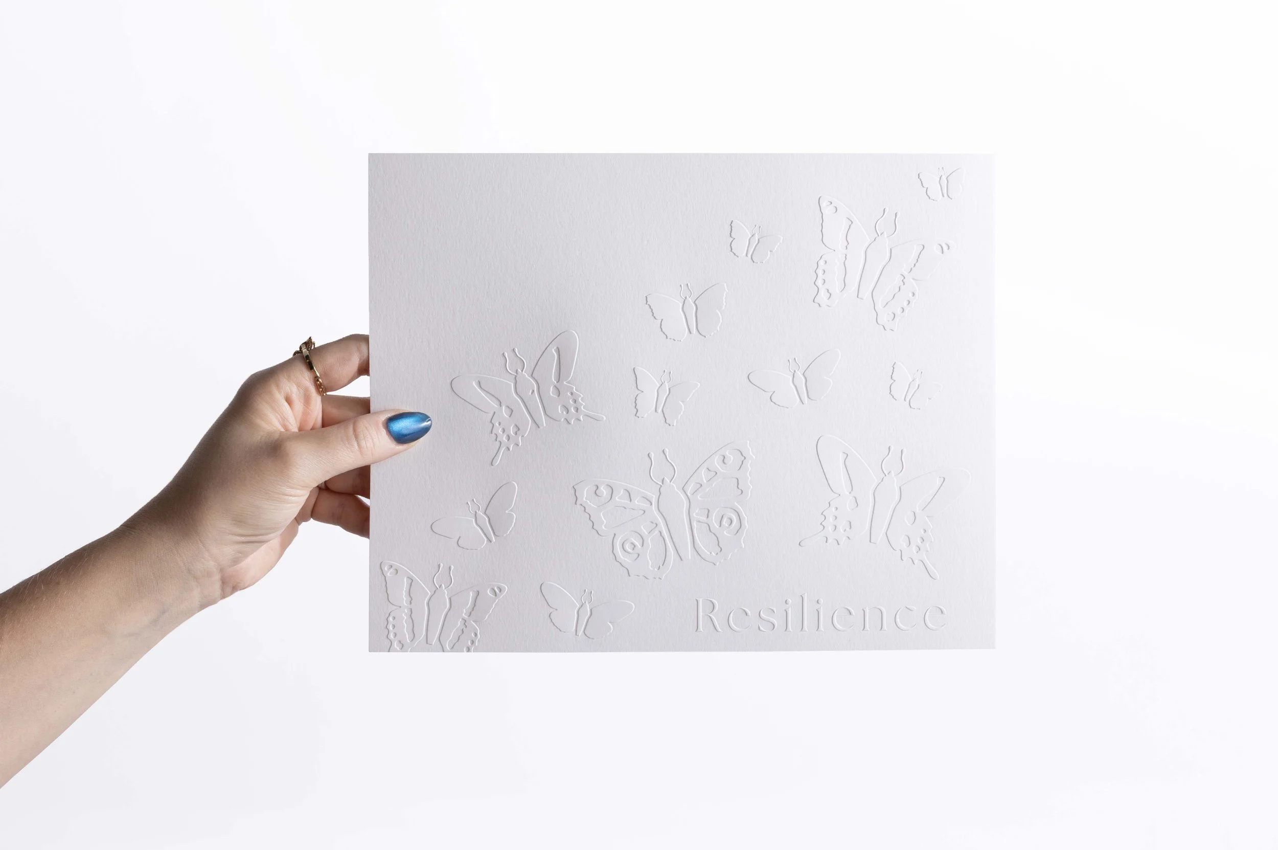 White embossed watercolor paper artwork featuring delicate butterflies.