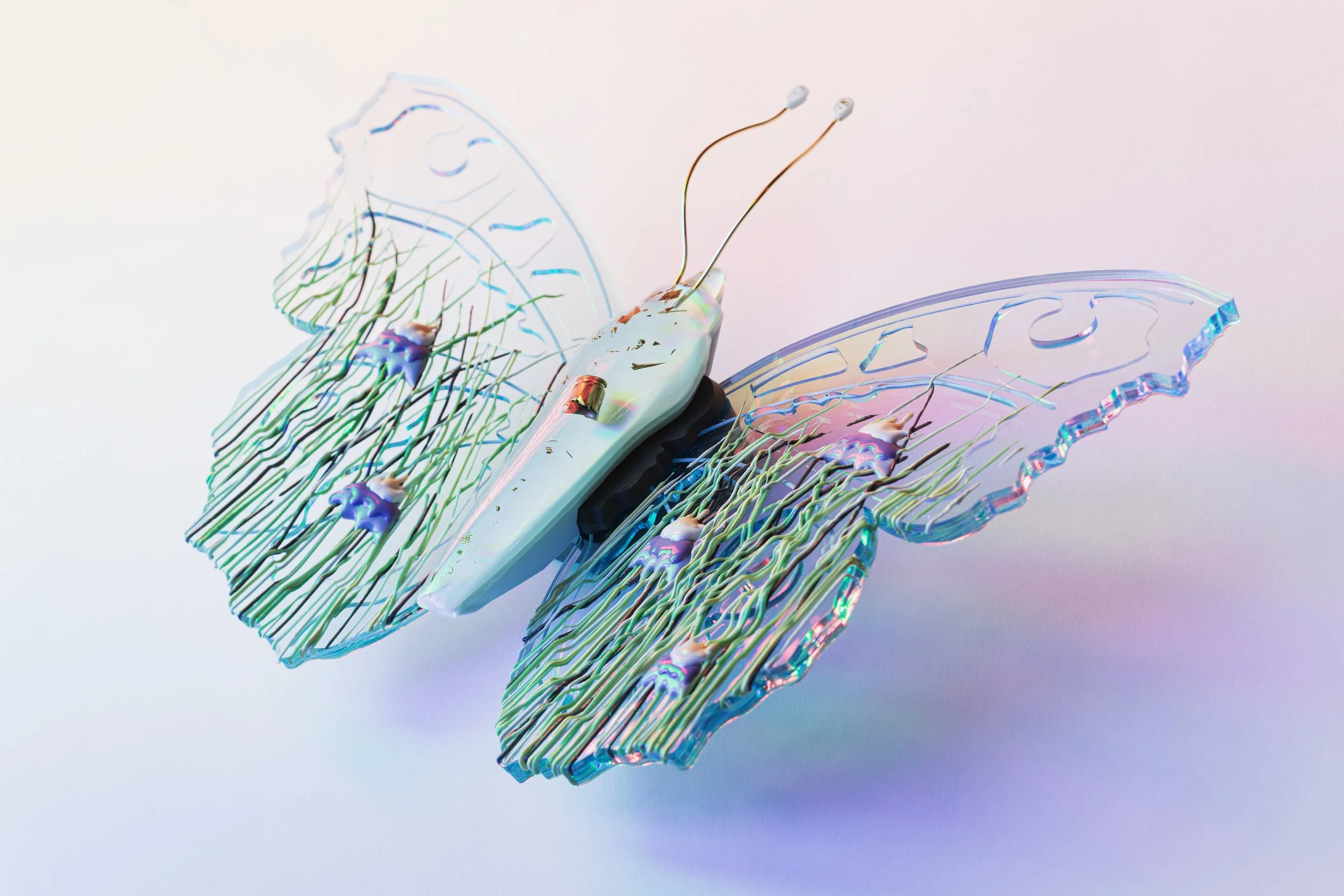 Close-up of a resin butterfly with colorful, iridescent wing details and thin antennae.