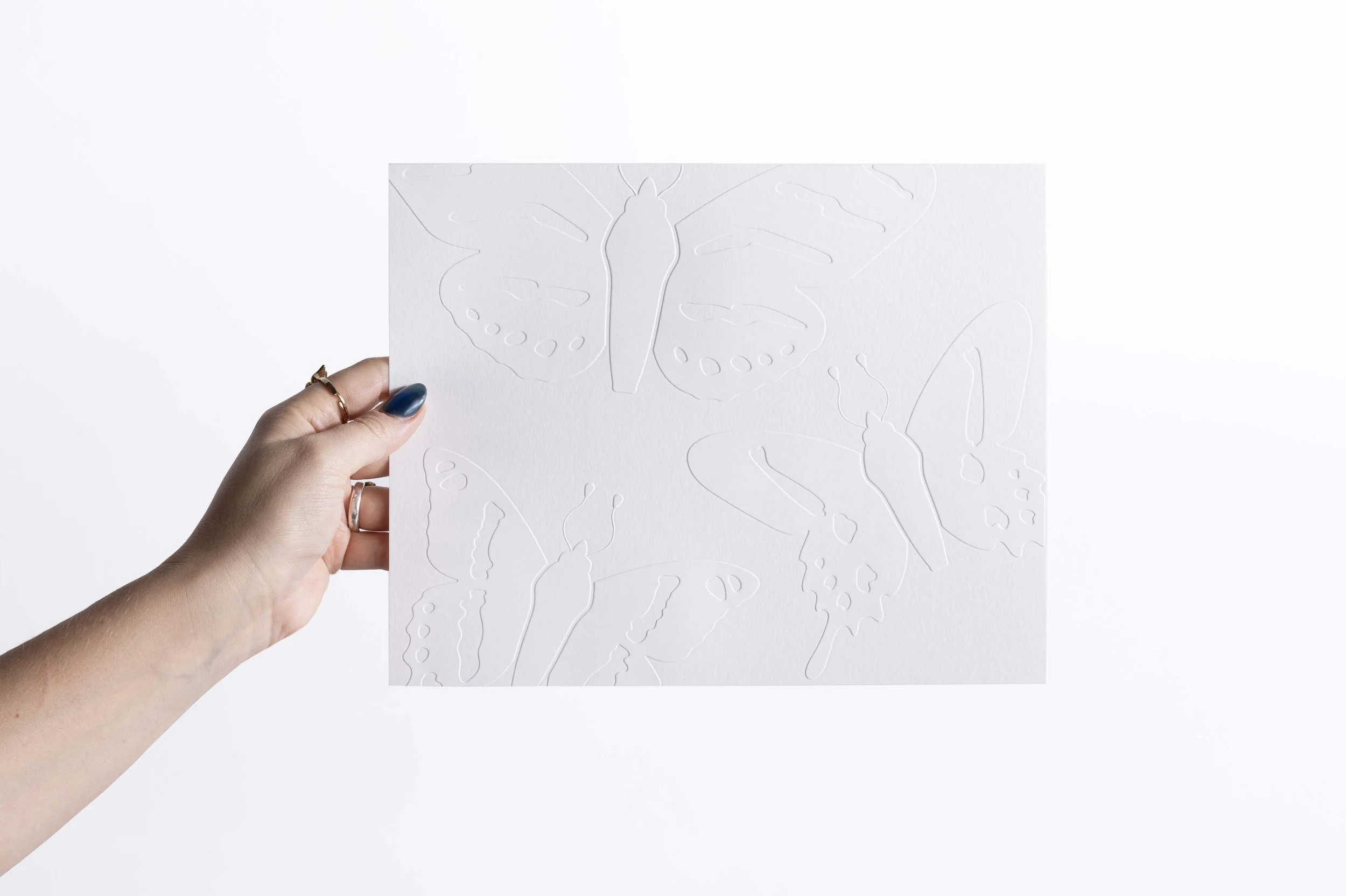 White embossed watercolor paper artwork featuring butterfly flutter.