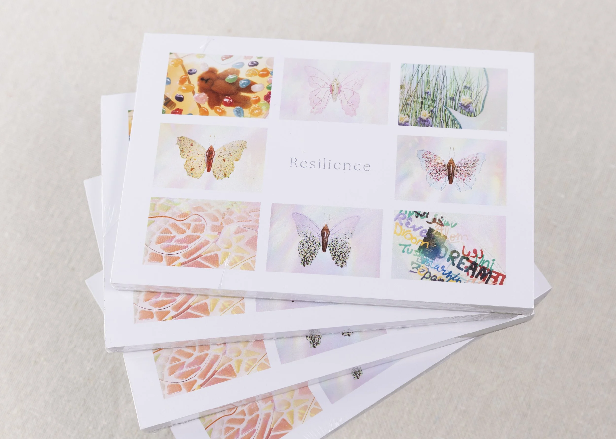Cover of the Resilience Postcard Book, Volume 1, showcasing a curated collection of colorful contemporary butterfly artworks.
