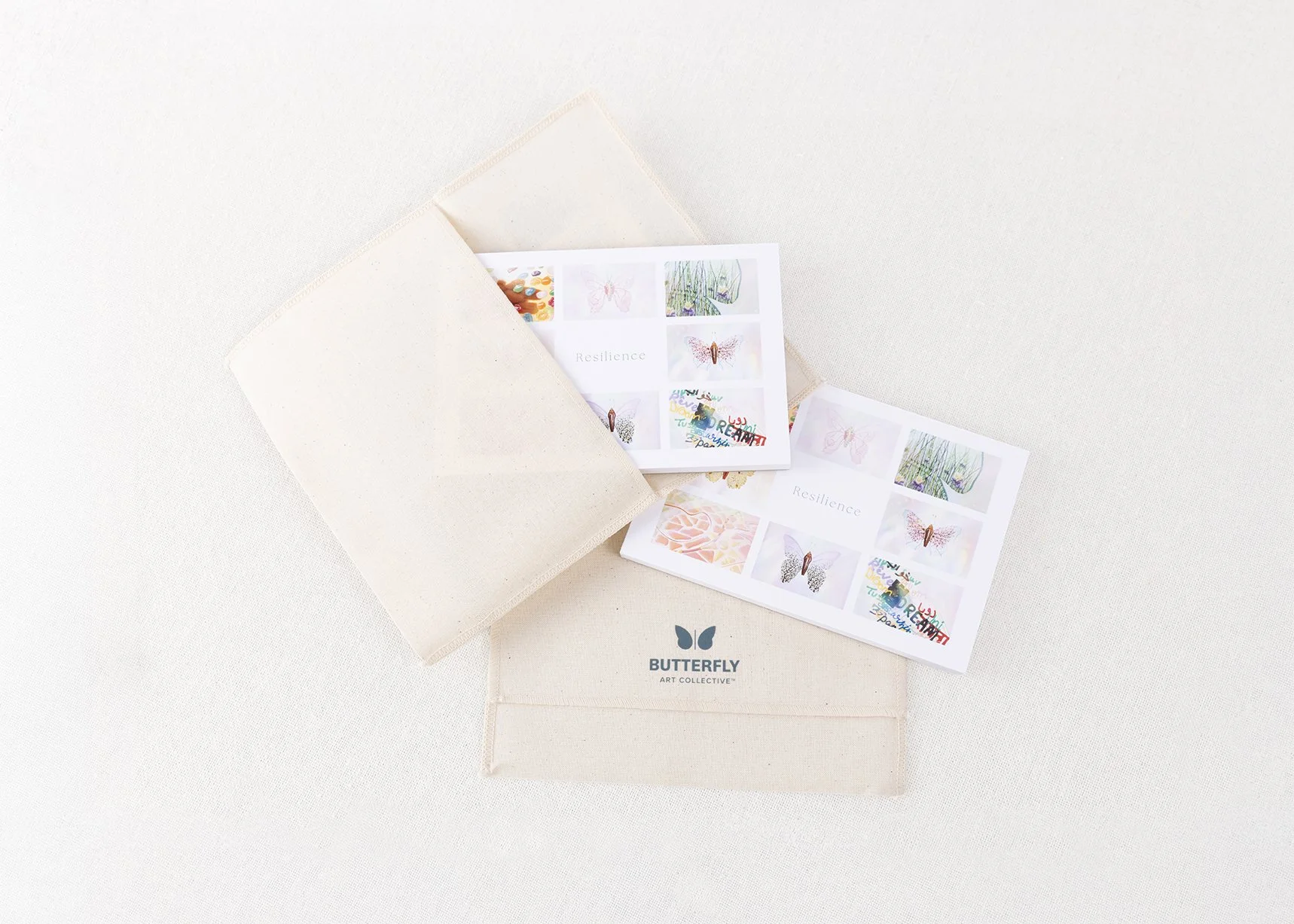 Resilience Postcard Book by Butterfly Art Collective displayed with its cotton canvas pouch and photographic art postcards.