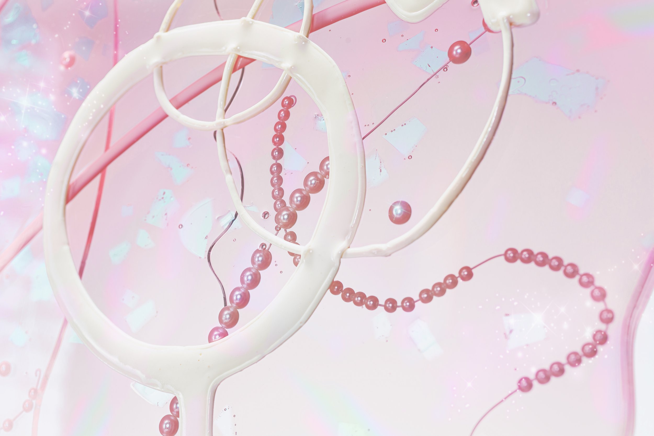 Close-up of a pink resin butterfly sculpture with pearls on strings, along with female symbol accents, creating a whimsical, pastel-themed design.