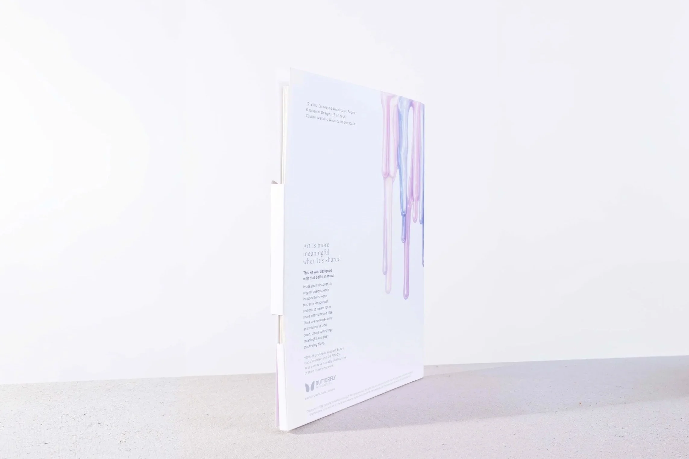 Side view of the Resilience packaging showing the dimensional structure, interior artwork, and lavender paint drip design.
