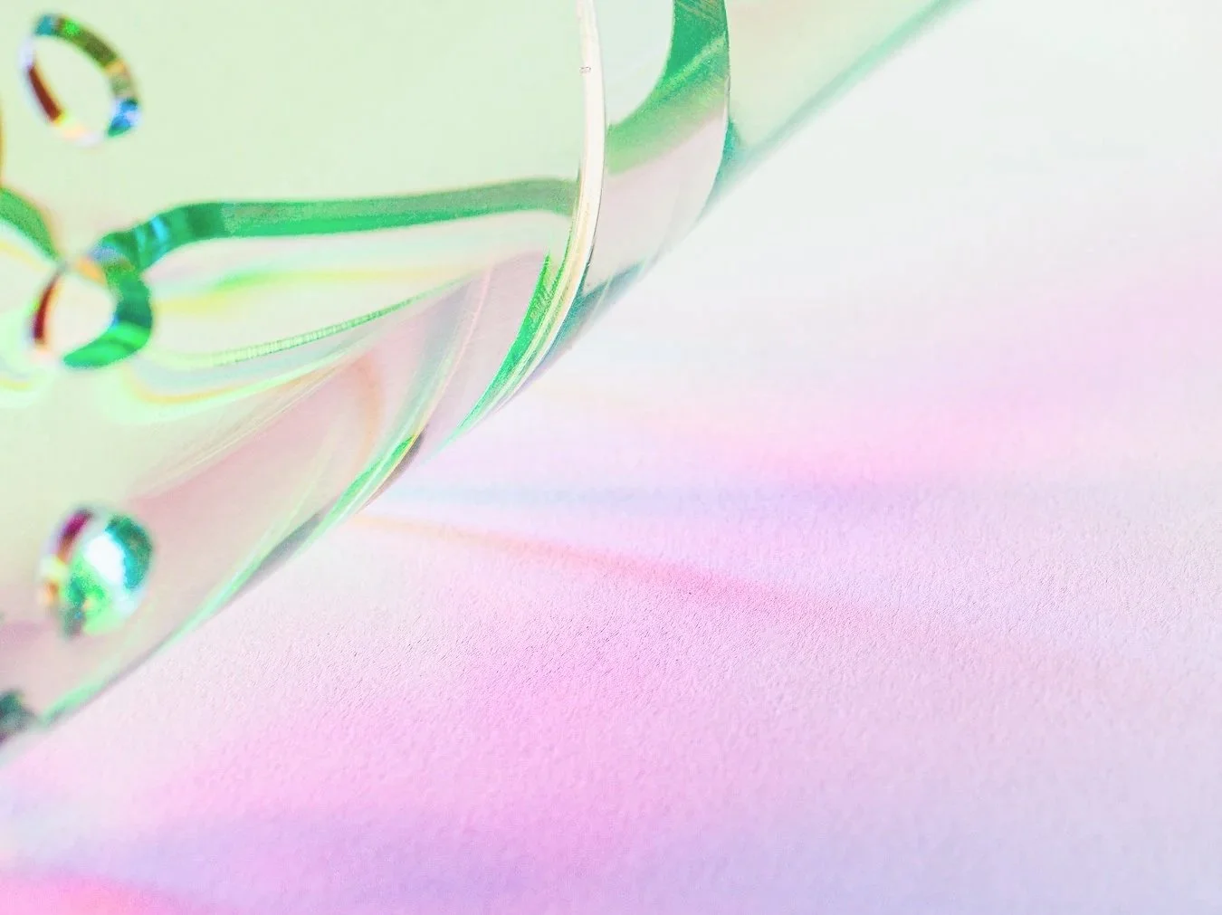 Close-up of an iridescent, holographic resin butterfly on a pastel pink surface.