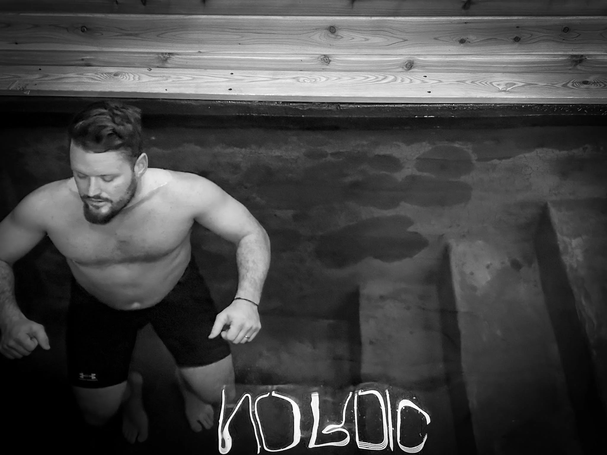 Man stepping out of cold plunge ice bath at Nordic on Nine sauna and wellness spa in New Windsor NY