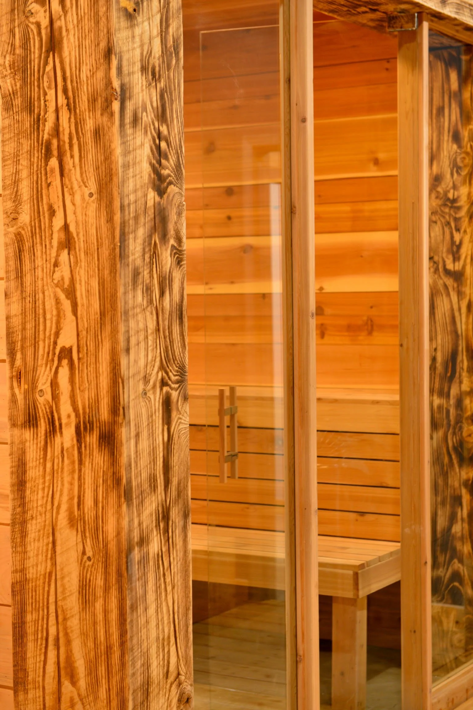 Cedar Finnish sauna with glass door and charred wood exterior framing at Nordic on Nine in New Windsor NY