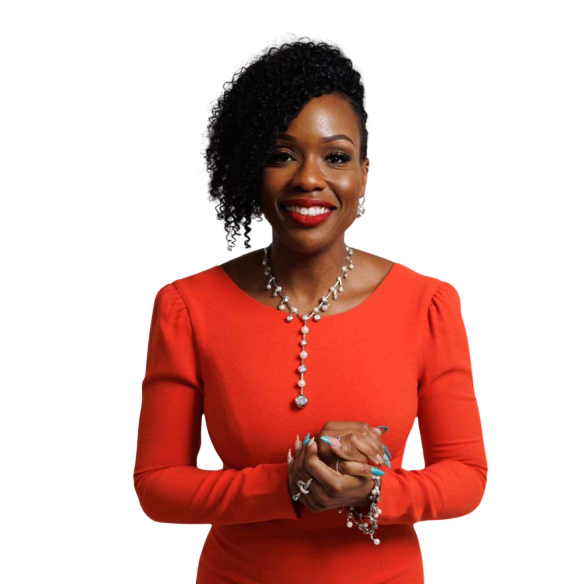 Smiling woman in a bright orange dress with curly hair and a long necklace, standing against a white background.
