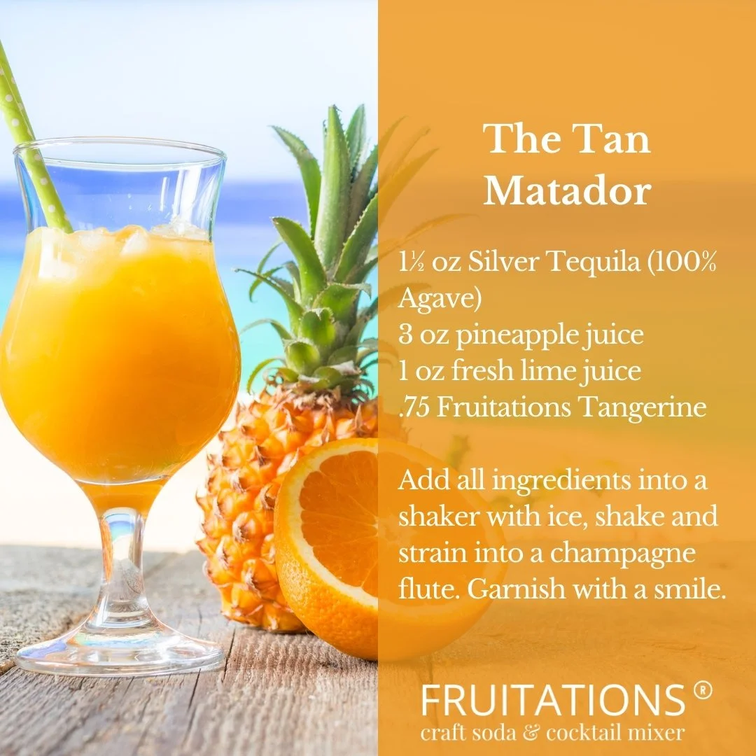 A tropical cocktail called The Tan Matador served with a straw, a pineapple and an orange garnish.  Imagine the sea, and a beach and clear sky.