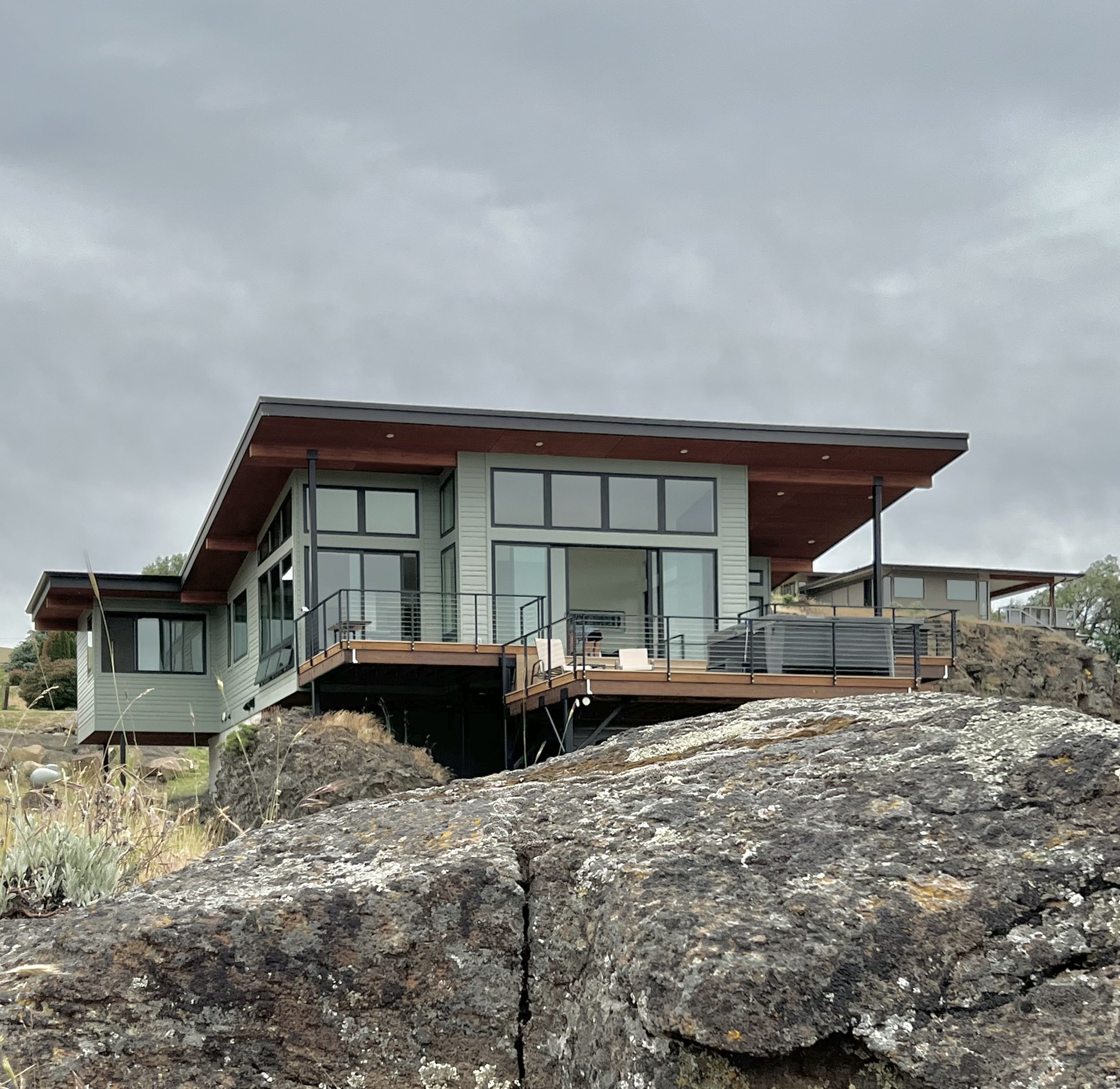 Modern house with large windows and a slanted roof on a rocky terrain