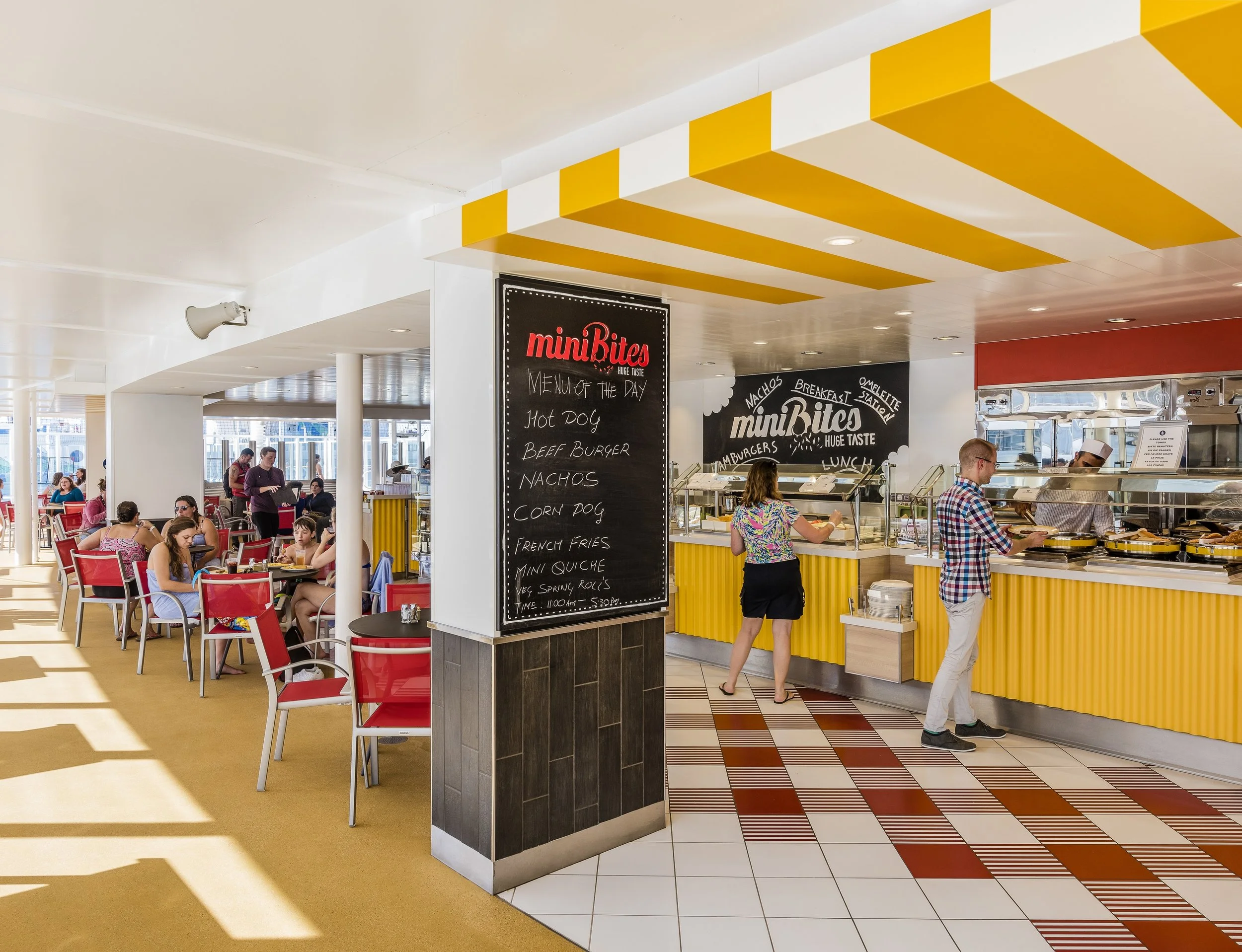 Cruise ship buffet restaurant with people dining and buffet menu on chalkboard