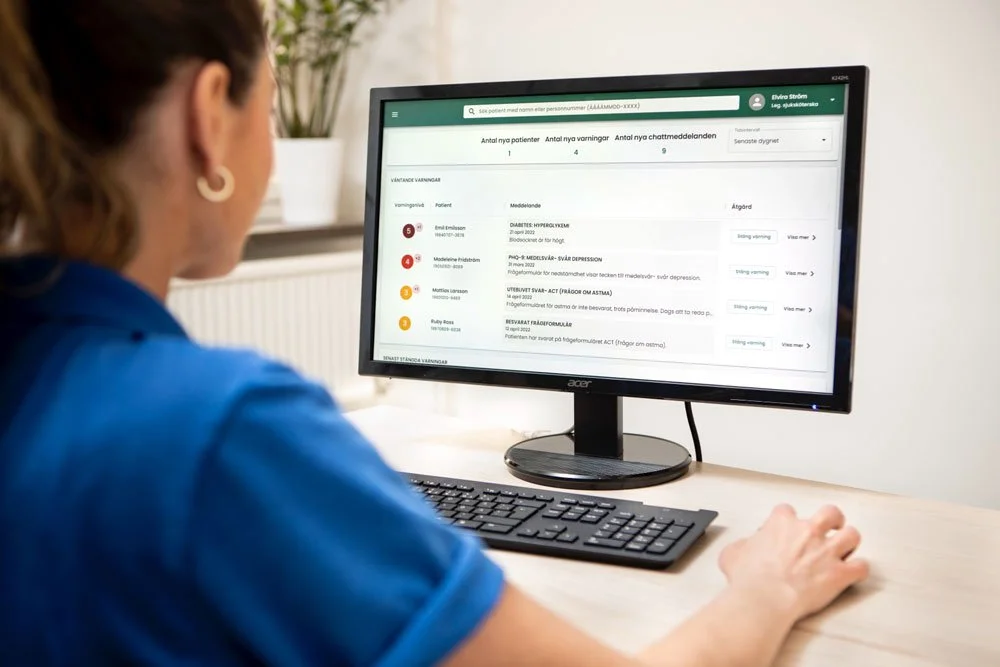 Kvinnlig läkare som går igenom en patients hälsodata på en datorskärm.