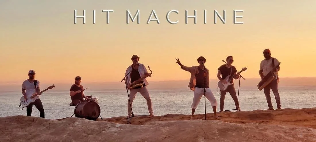 Hit Machine performing live on stage with an energetic crowd dancing