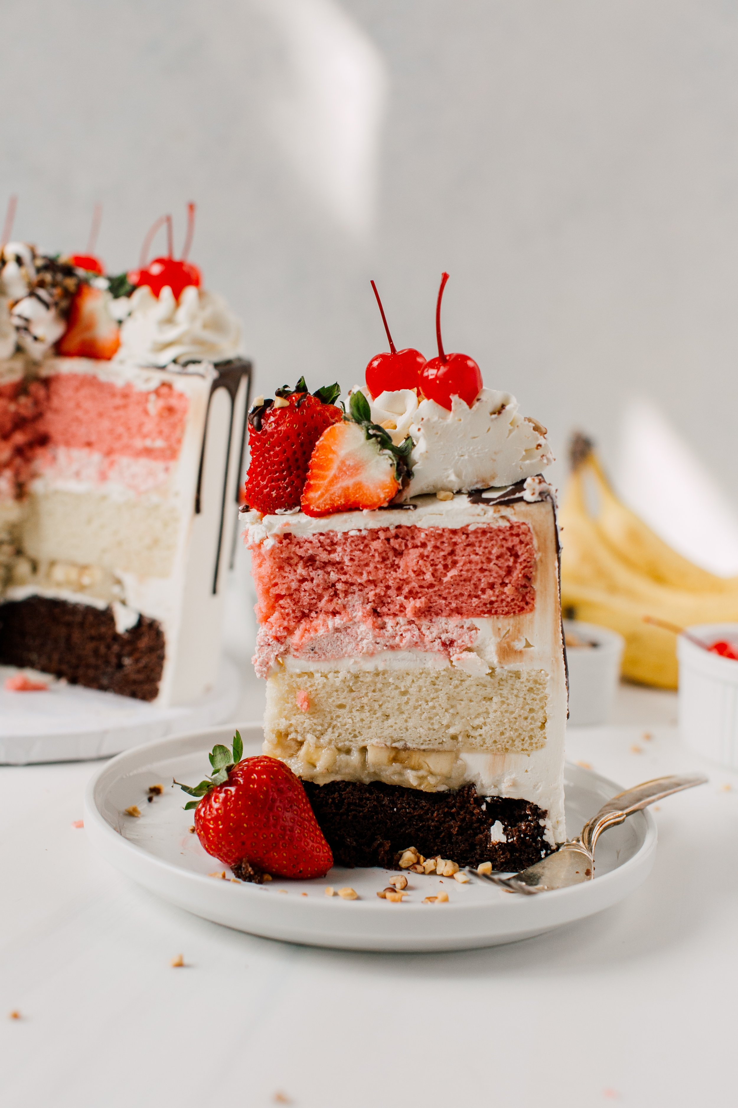 Seattle food photographer Banana split flavored cake slice elegantly styled with ingredients on white plate