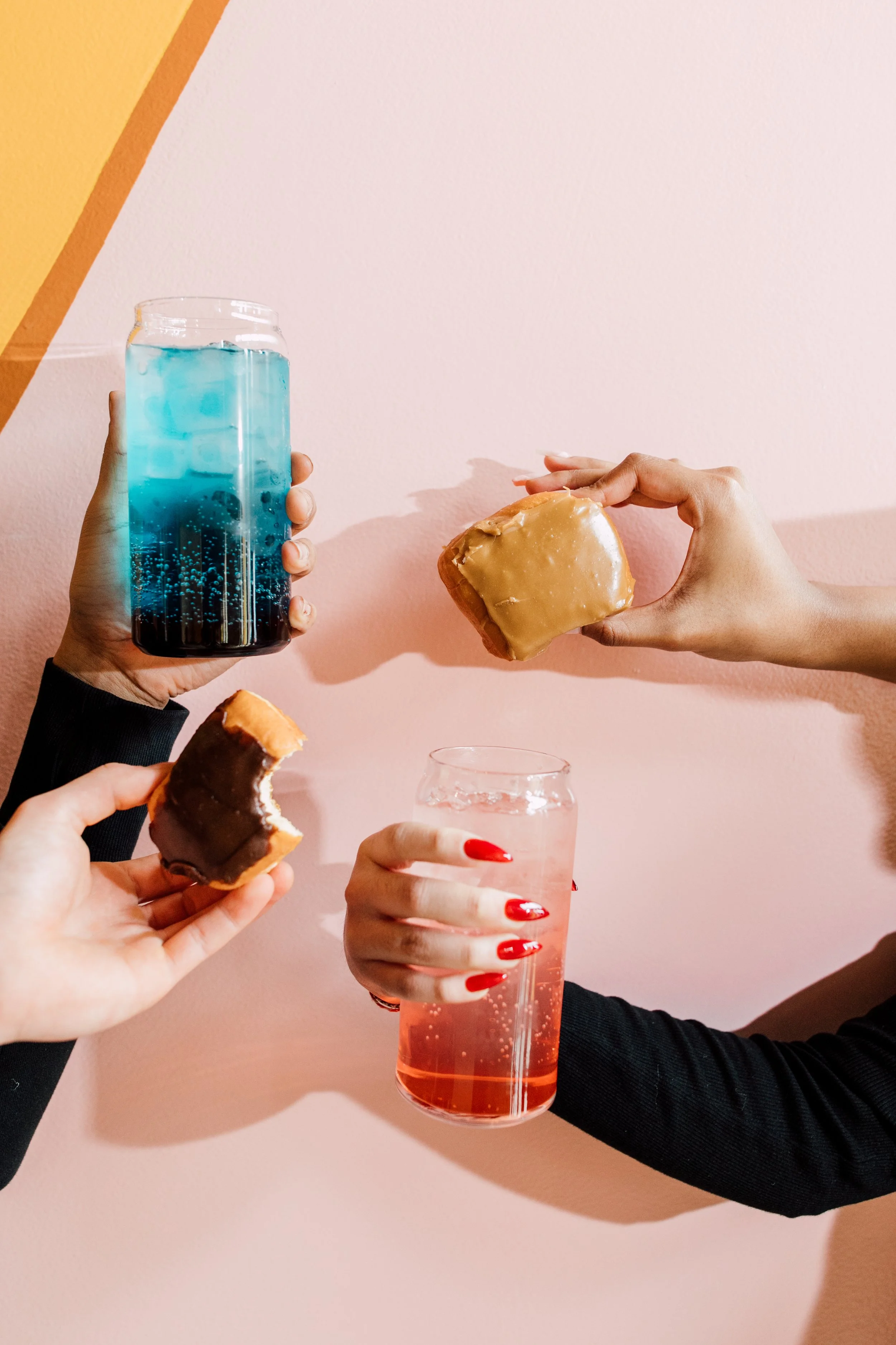 donuts and colorful energy drinks against a pink wall coffee shop photographer seattle restaurant photography