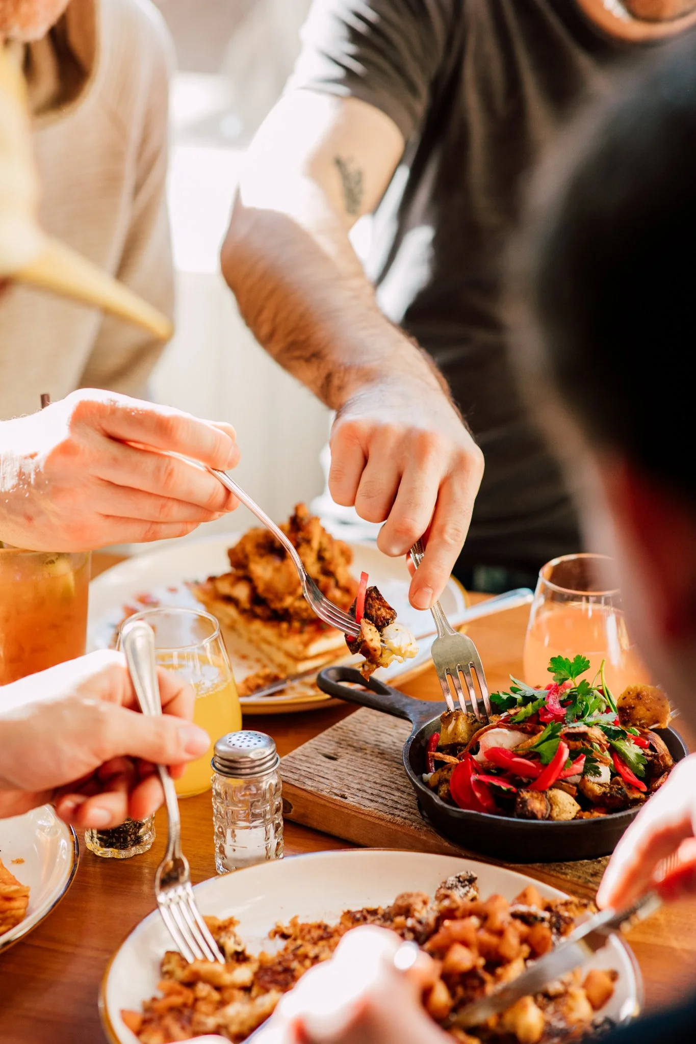 everyone digging into a breakfast plate together in the morning sun
