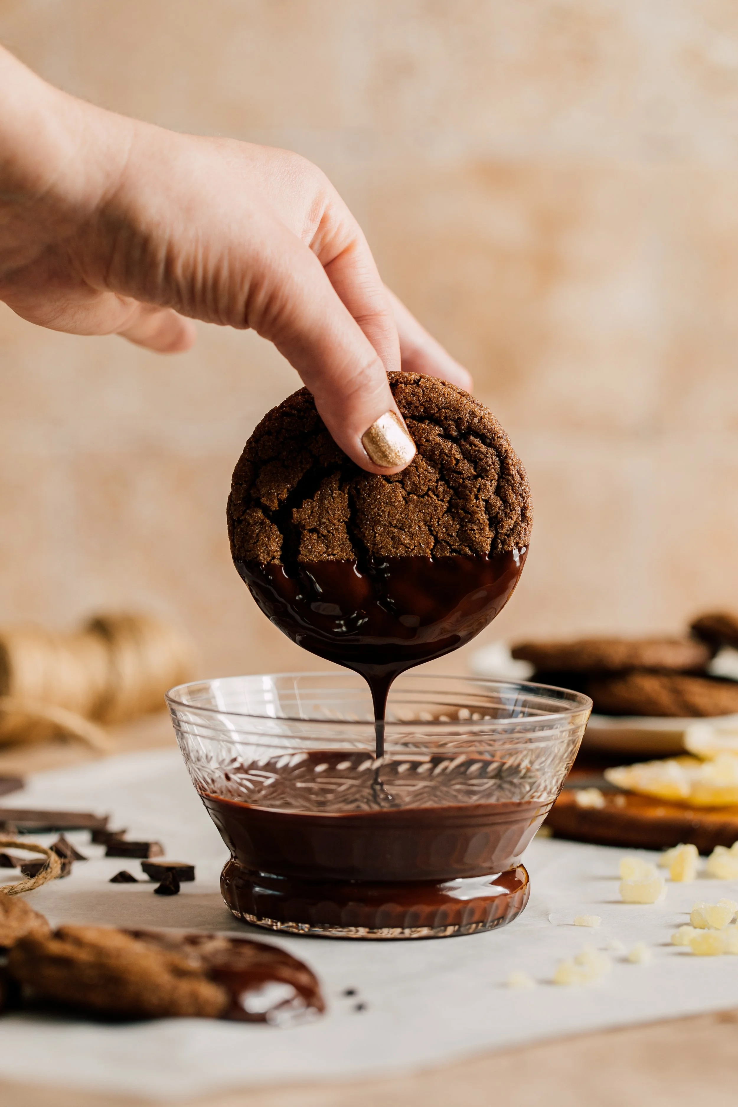 chocolate molasses cookie dipped in dripping melted chocolate with hand in frame seattle food cookie photographer