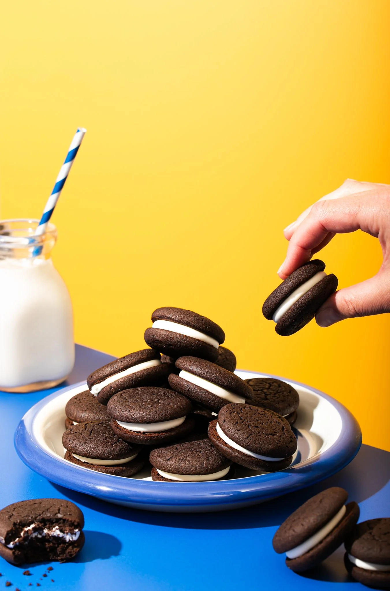 someone snagging oreo off giant cookie pile with bright colors and fresh milk seattle dessert cookie photographer 