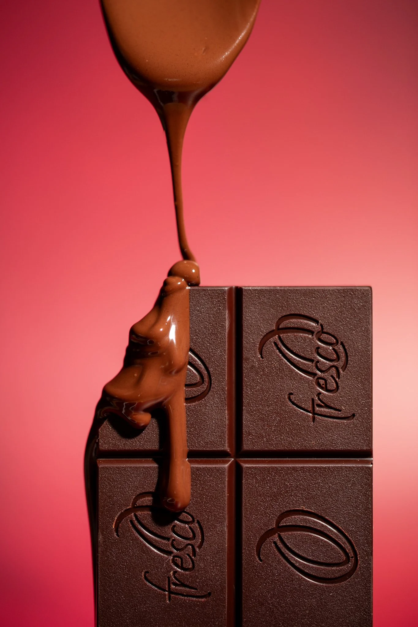 milk chocolate dripping down a chocolate bar on a bold red background seattle food photographer
