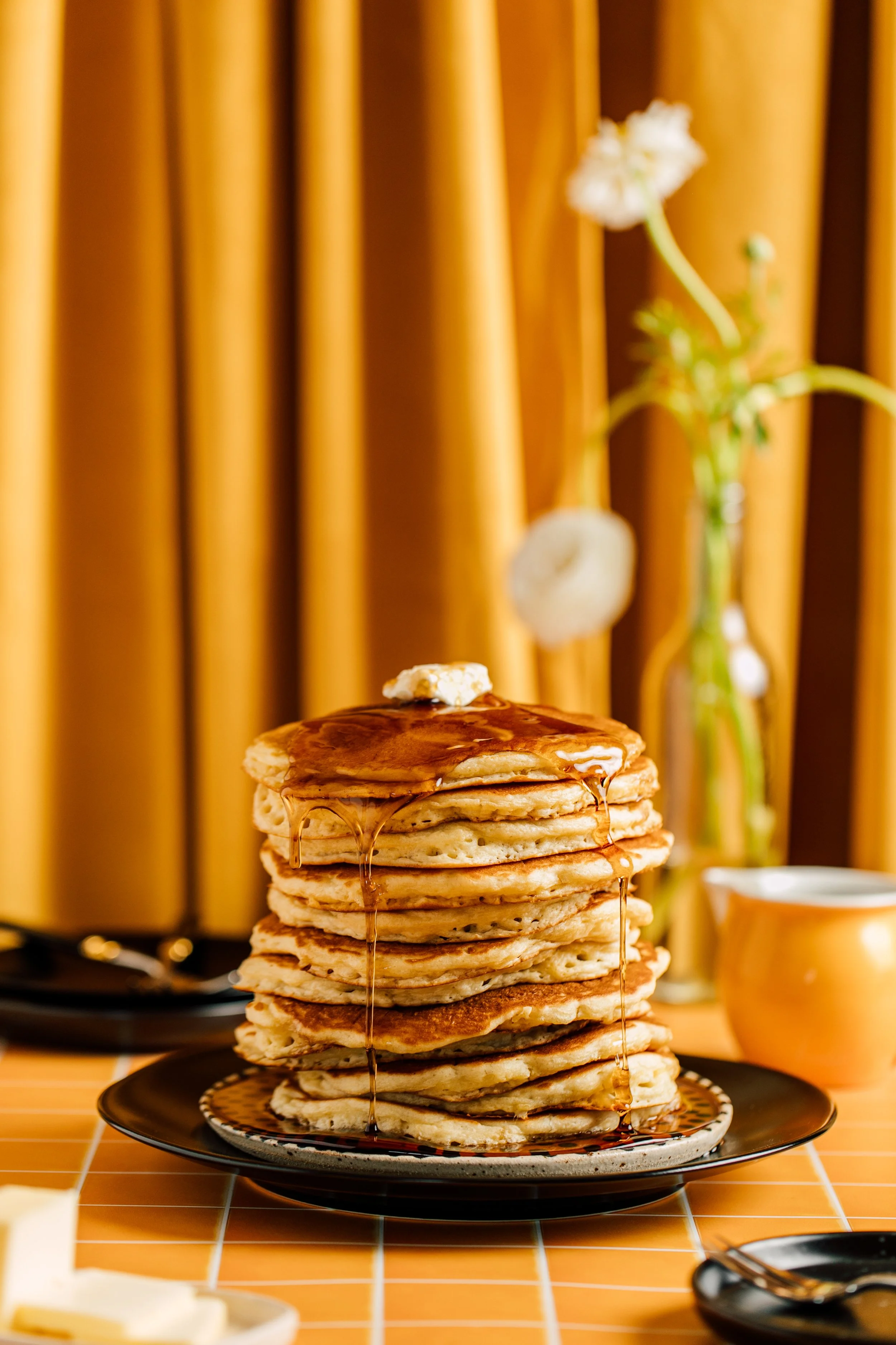 extra tall stack of pancakes on a yellow velvet background editorial style imagery seattle food photographer