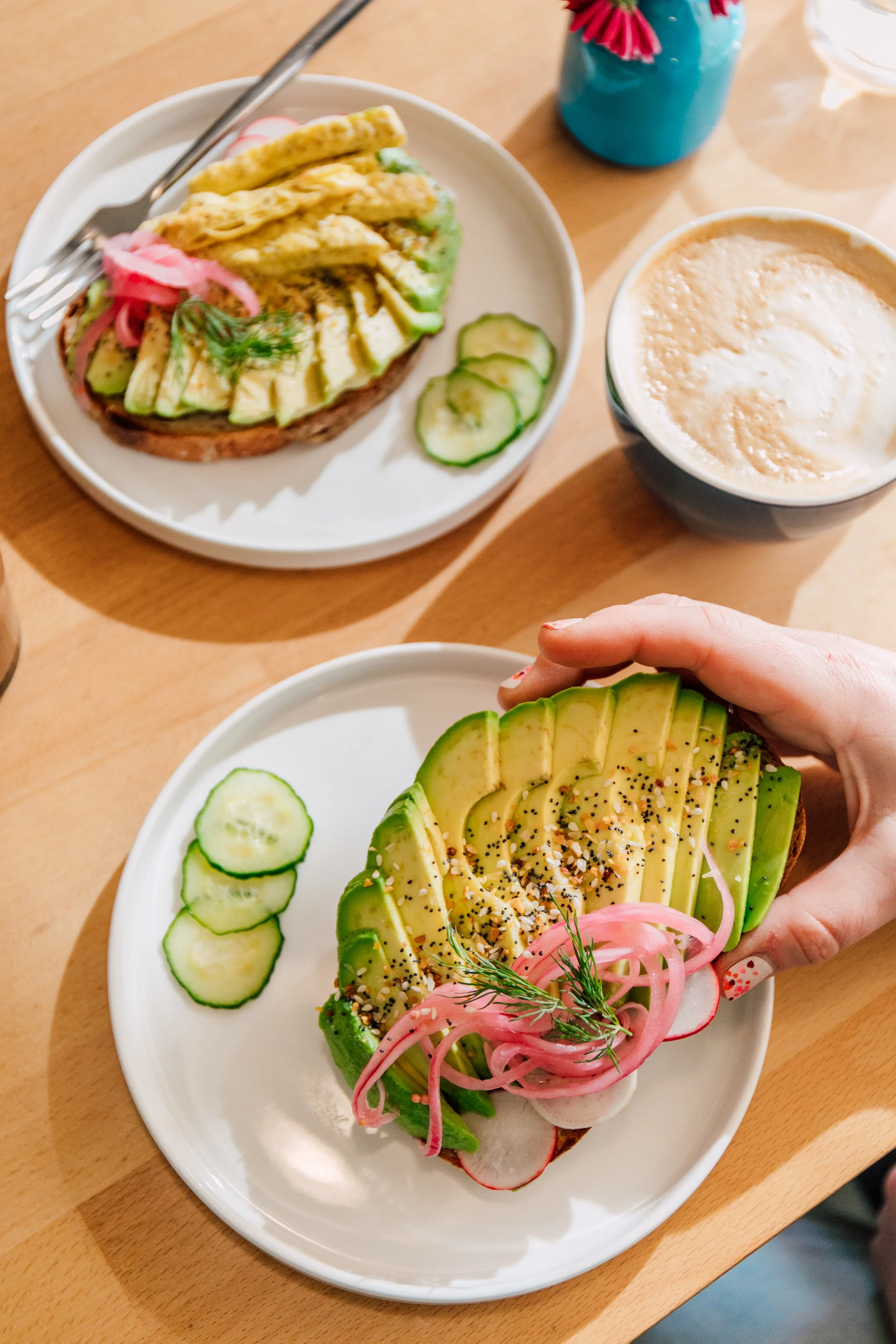 hand picking up fresh avocado toast local bakery cafe seattle restaurant photographer