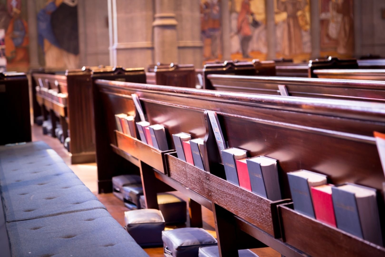 Church pews with hymnals and kneelers