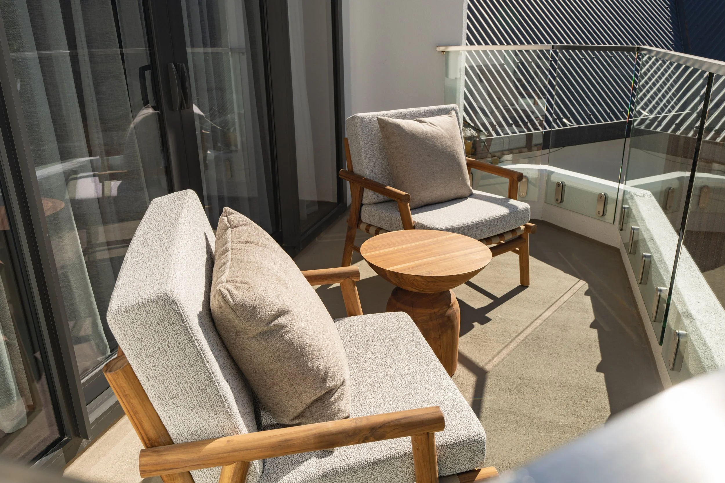 Outdoor seating area with cushioned chairs and mountain views.